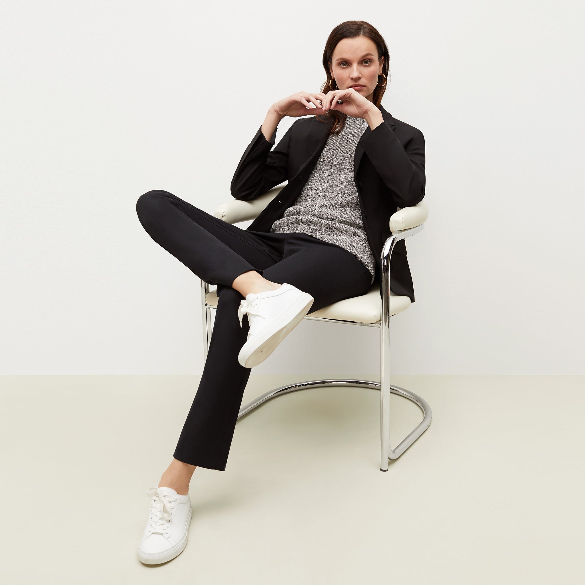 Front image of a woman sitting wearing the Barbara Sweater—Knit Boucle in Black / White