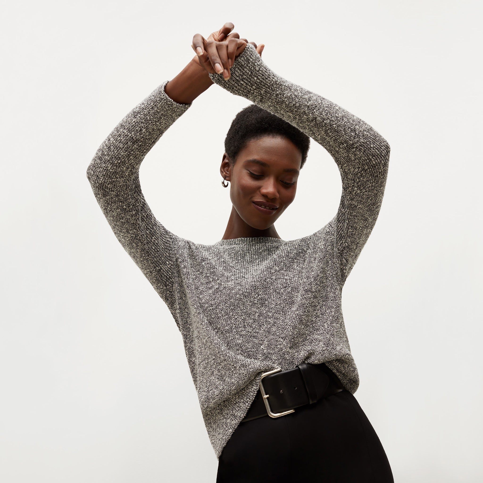Front image of a woman standing wearing the Butler Sweater—Knit Boucle in Black / White 