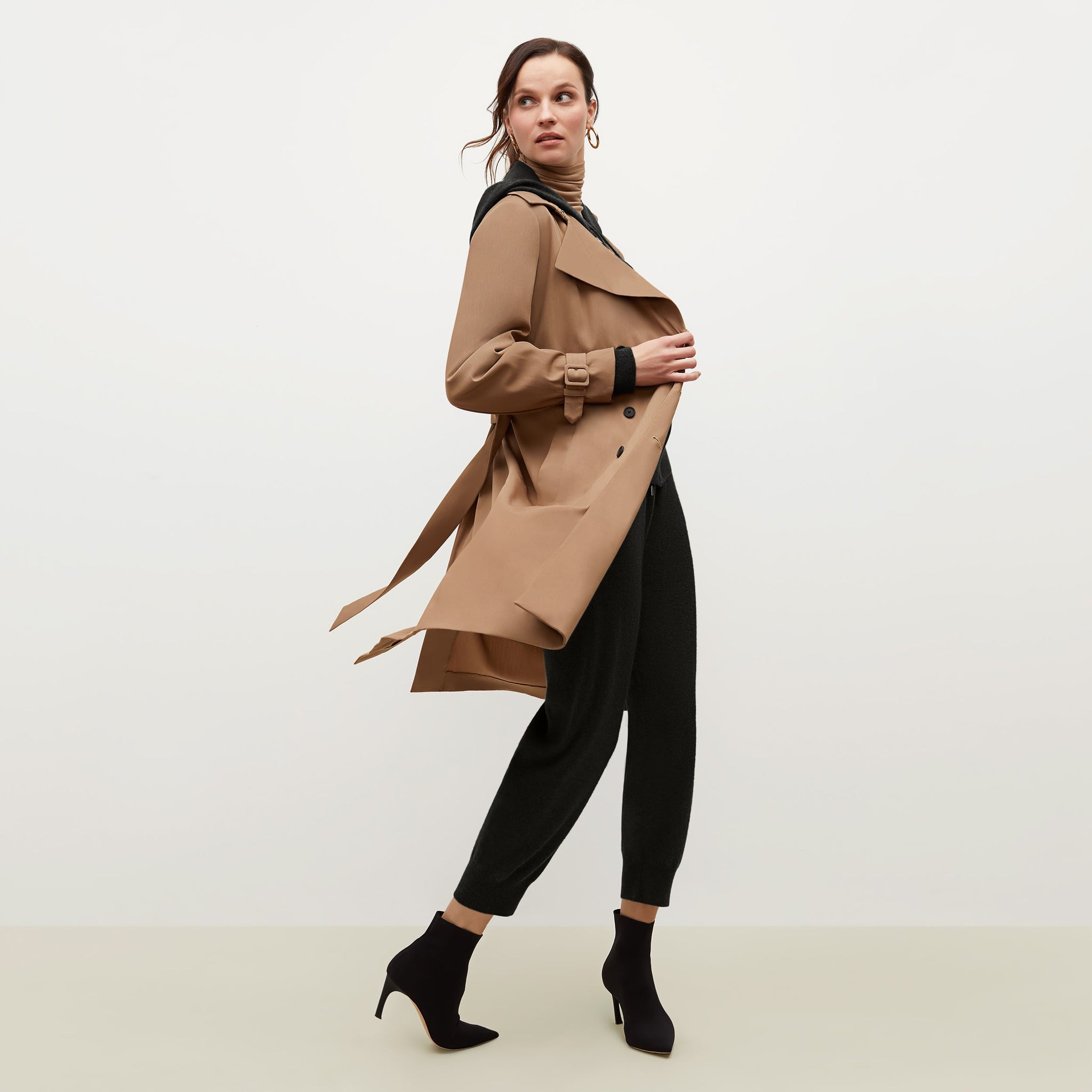 Side image of a woman standing wearing the Jensen trench in Saddle 