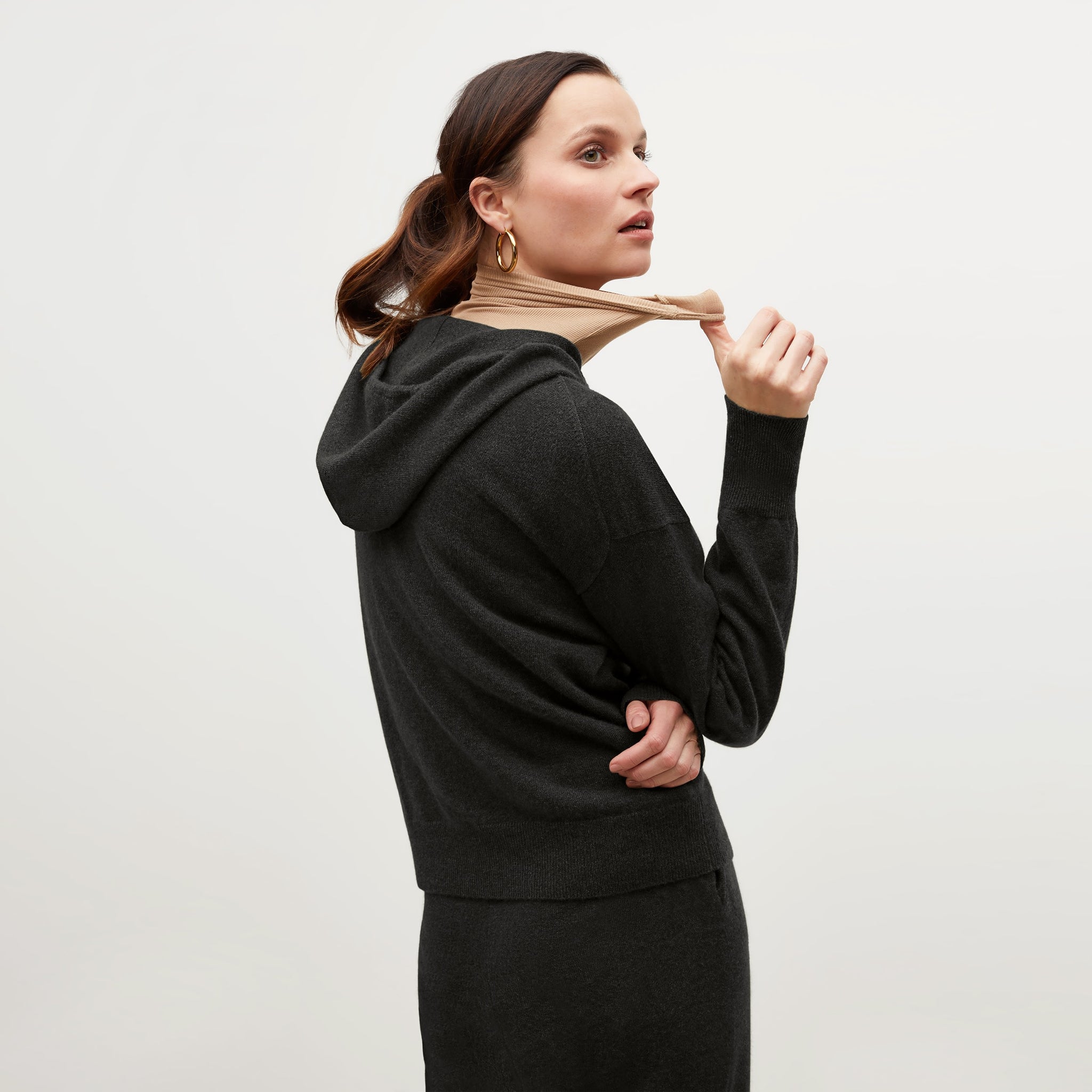 Back image of a woman standing wearing the Judith Hoodie—Cashmere in Black
