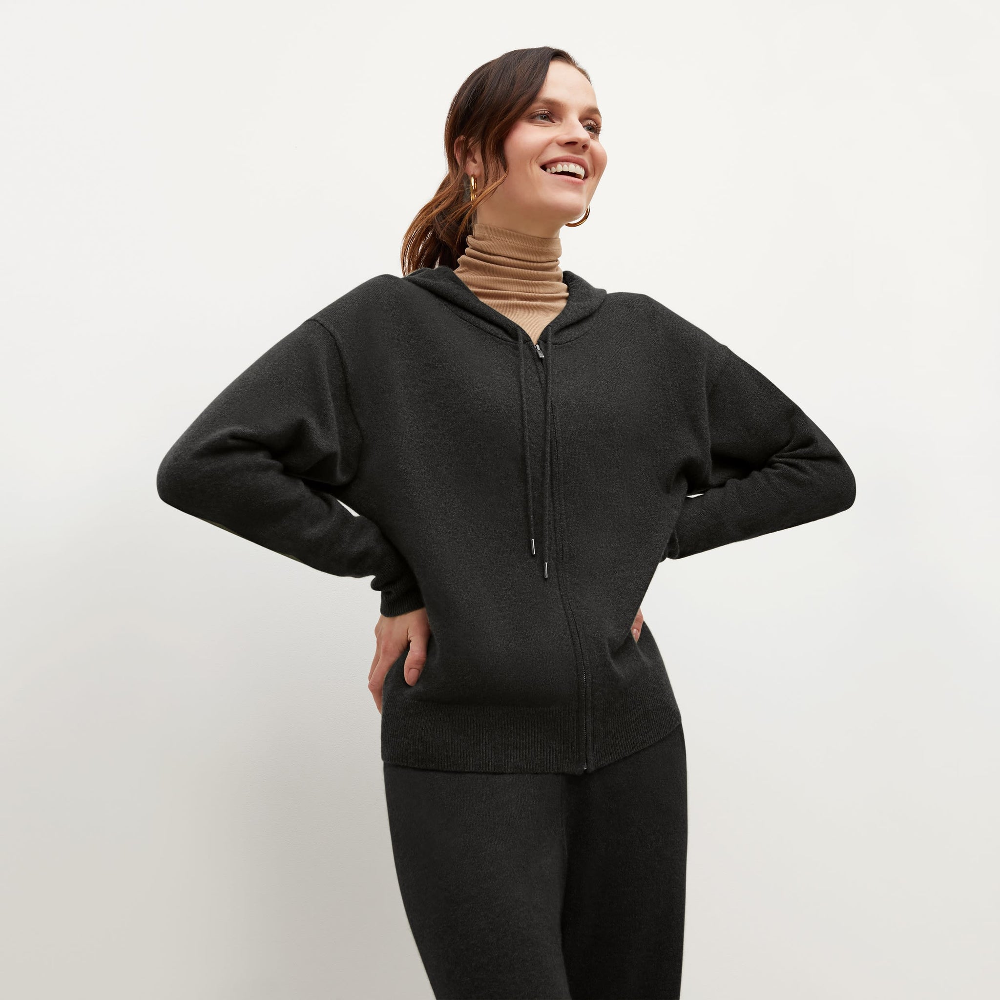 Front image of a woman standing wearing the Judith Hoodie—Cashmere in Black 