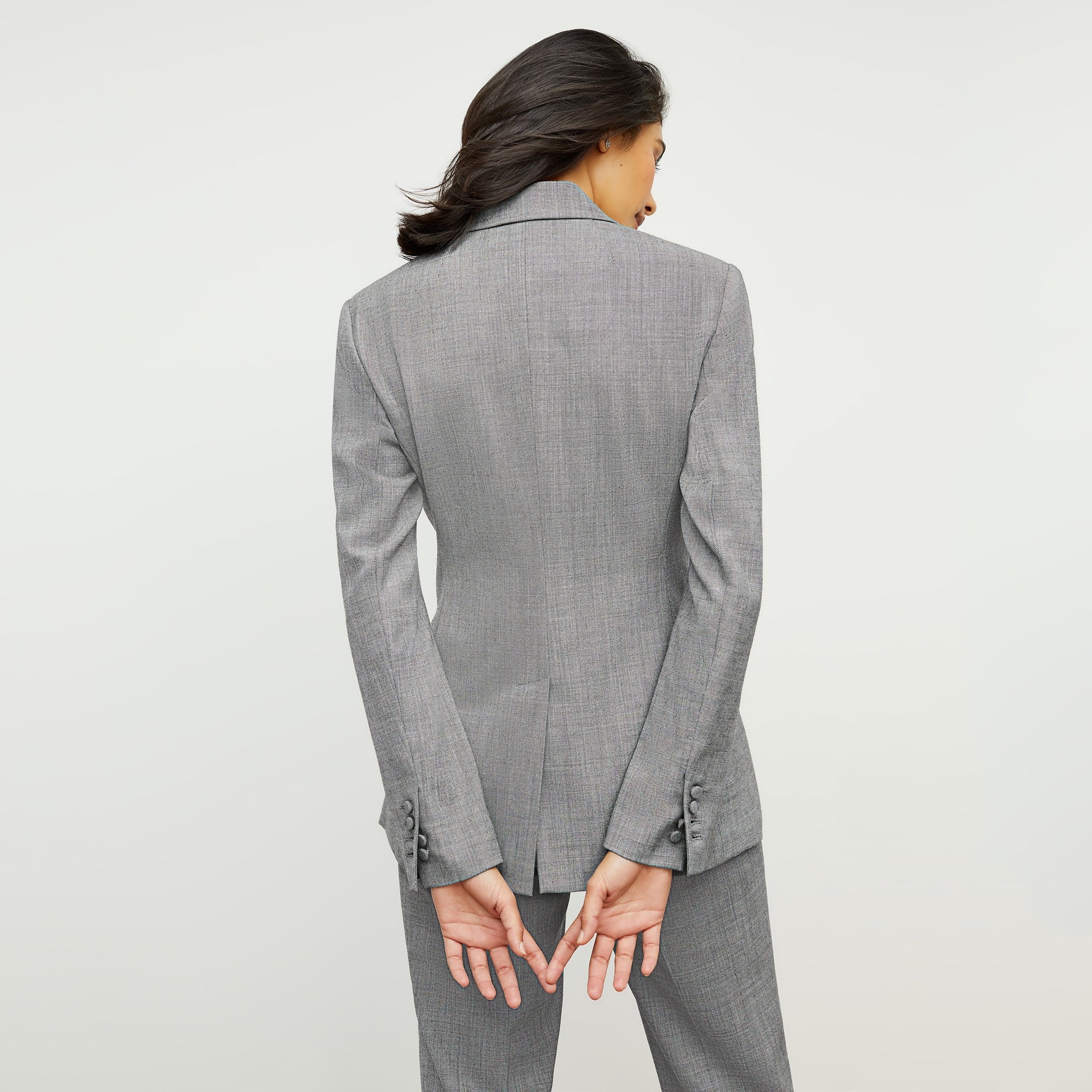 Back image of a woman standing wearing the gaia jacket in sharkskin in black and white