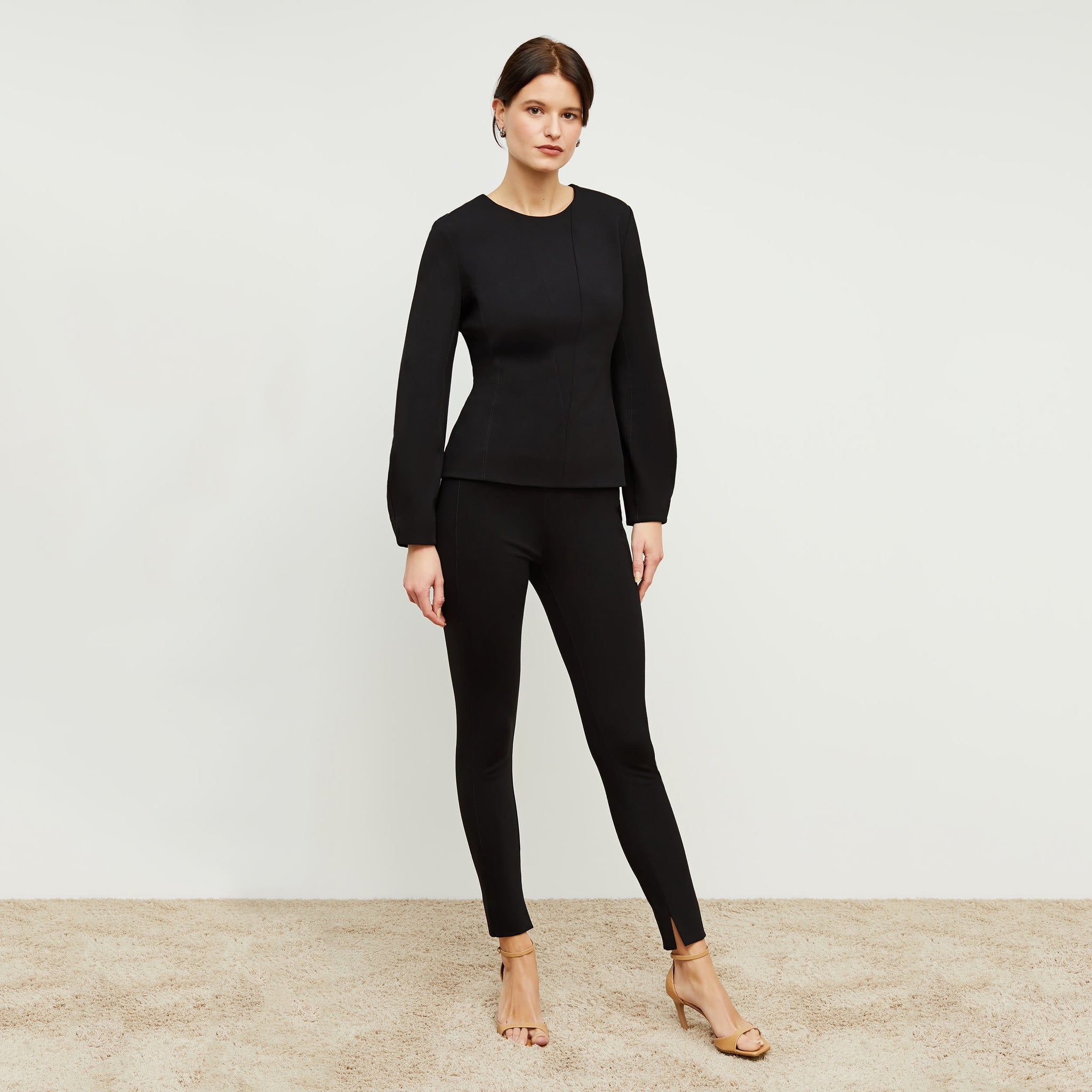 Front image of a woman standing wearing the rashida top in black