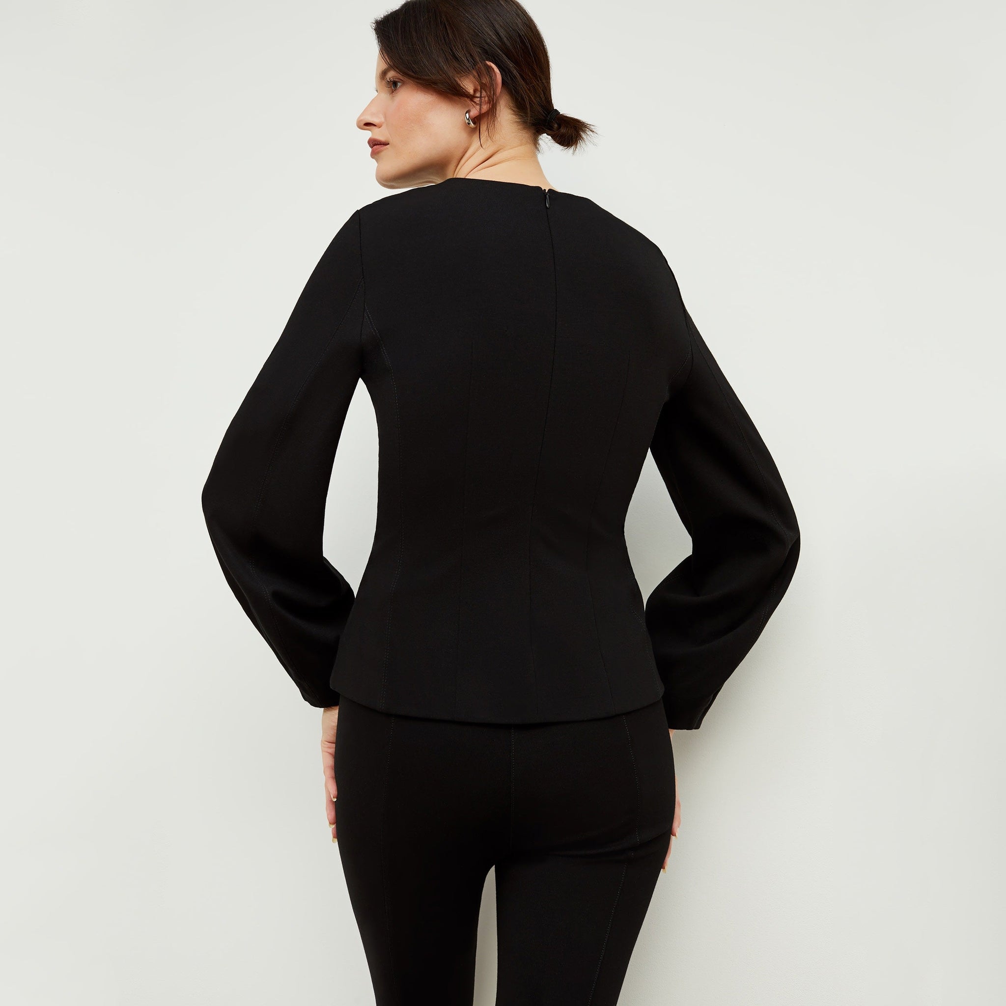 Back image of a woman standing wearing the rashida top in black