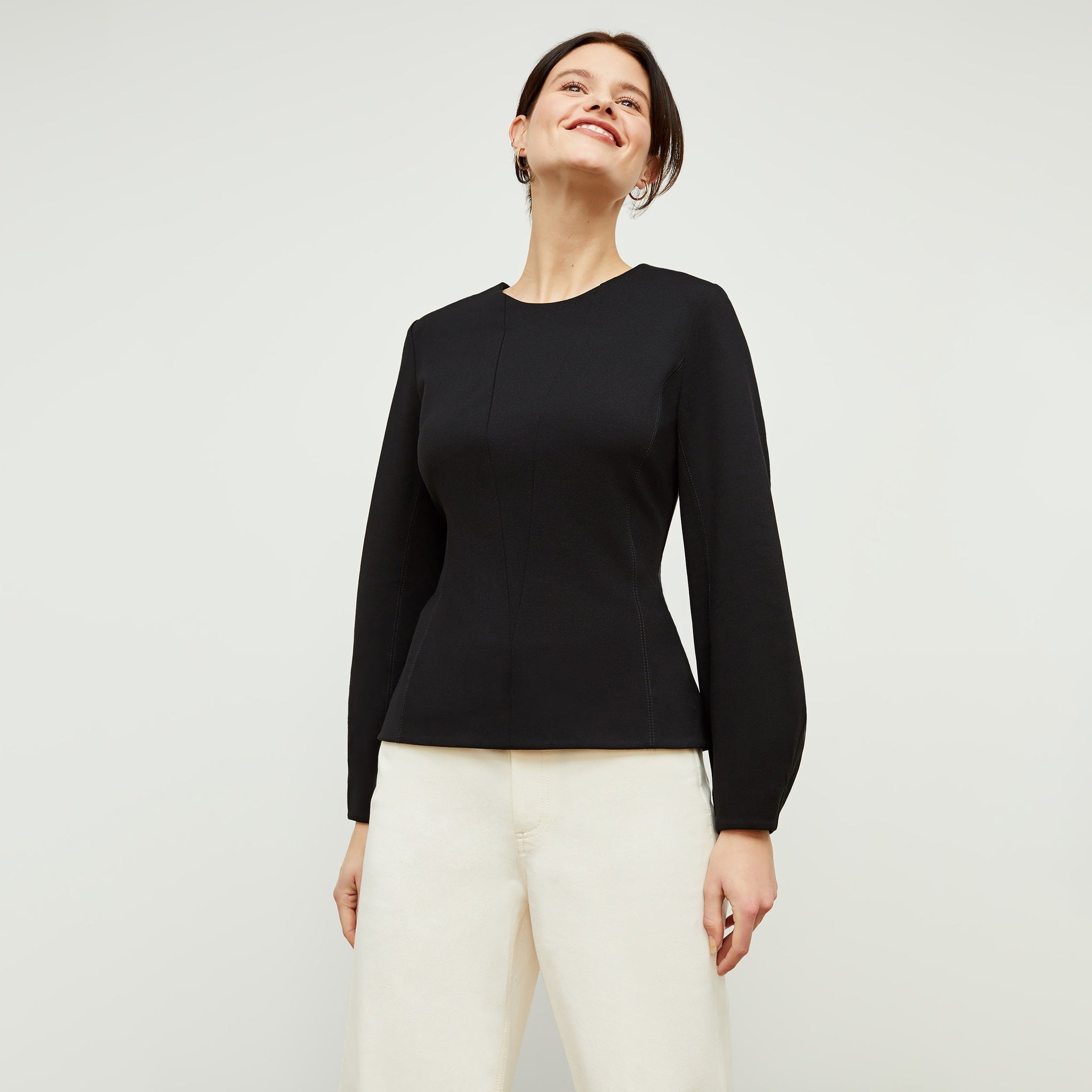 Front image of a woman standing wearing the rashida top in black