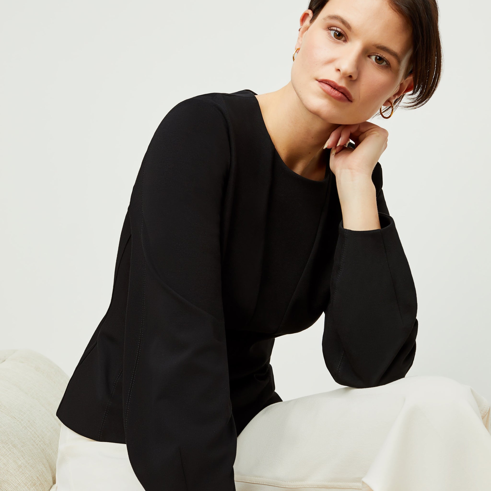 Detail image of a woman standing wearing the rashida top in black