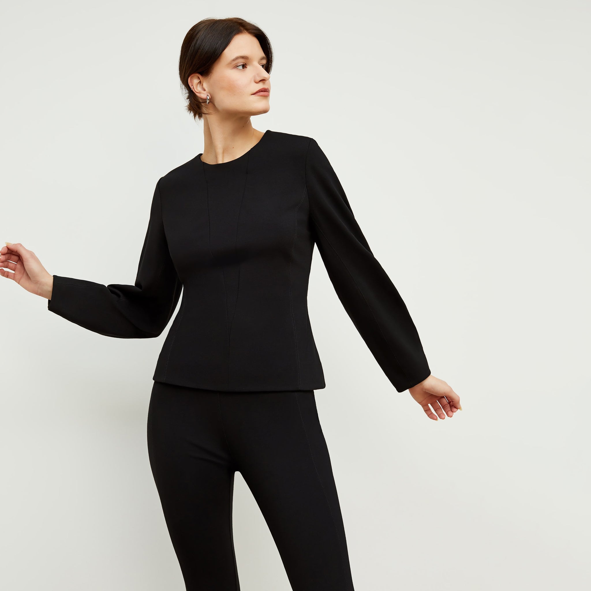 Front image of a woman standing wearing the rashida top in black