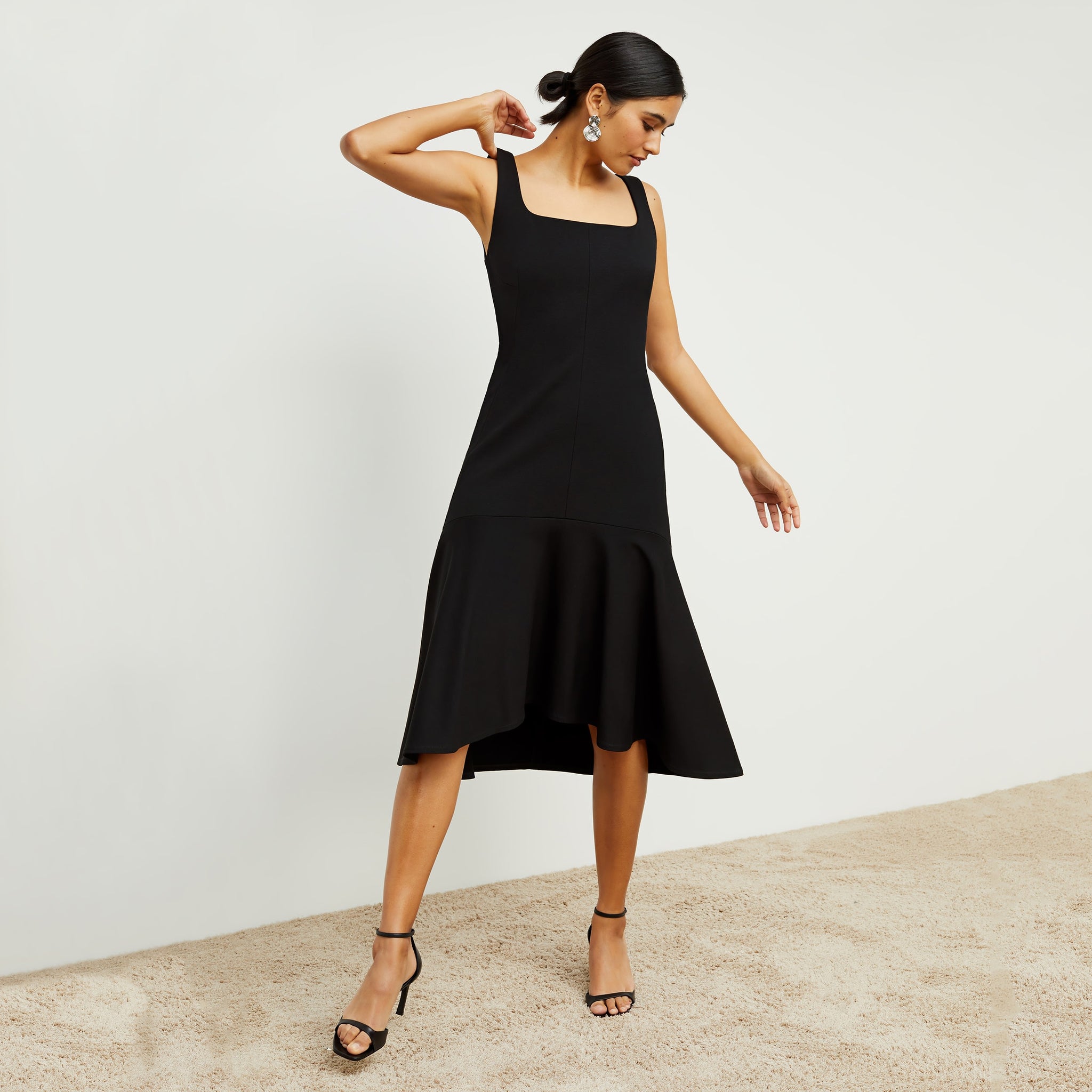 Front image of a woman standing wearing the james dress in black