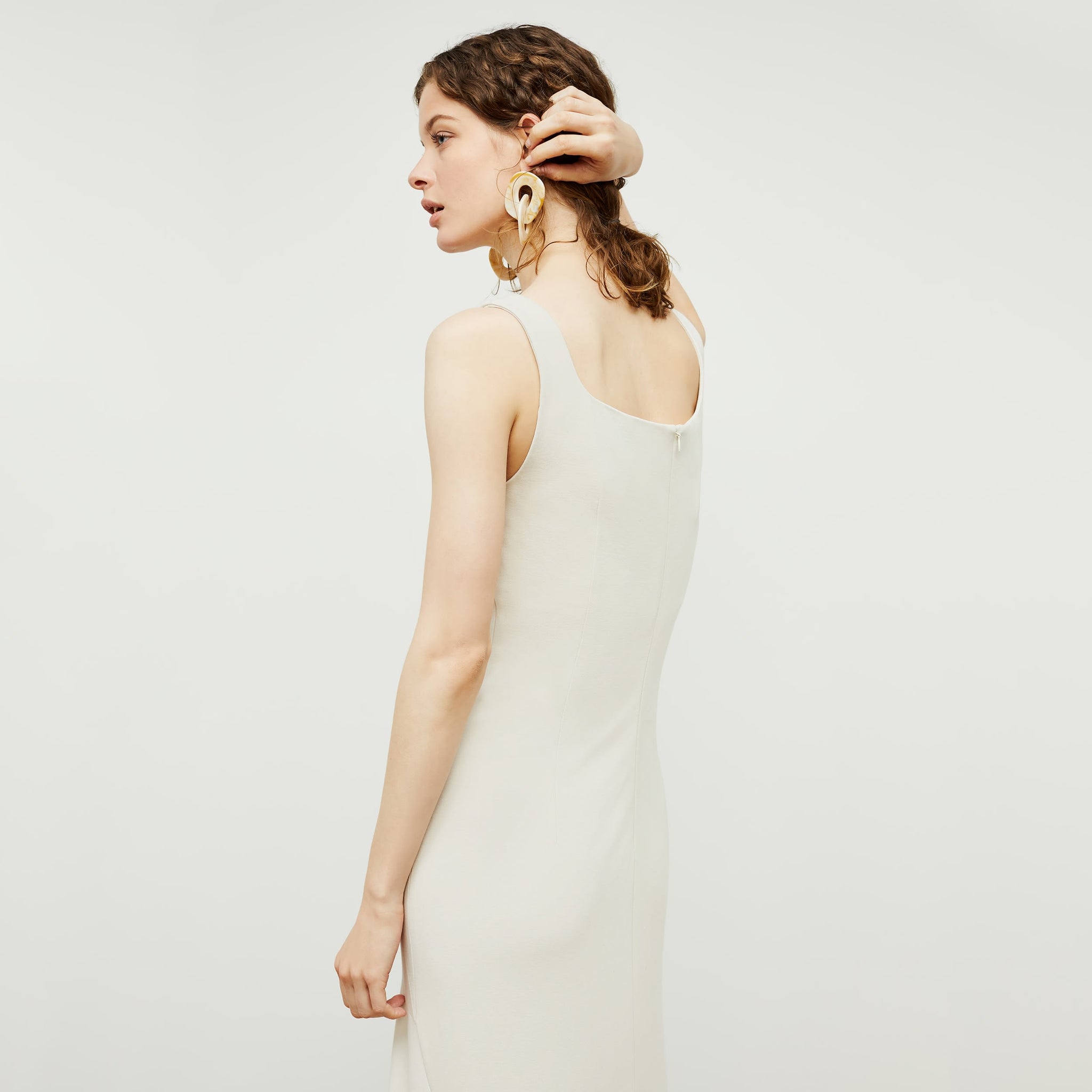 Back image of a woman standing wearing the james dress in pearl