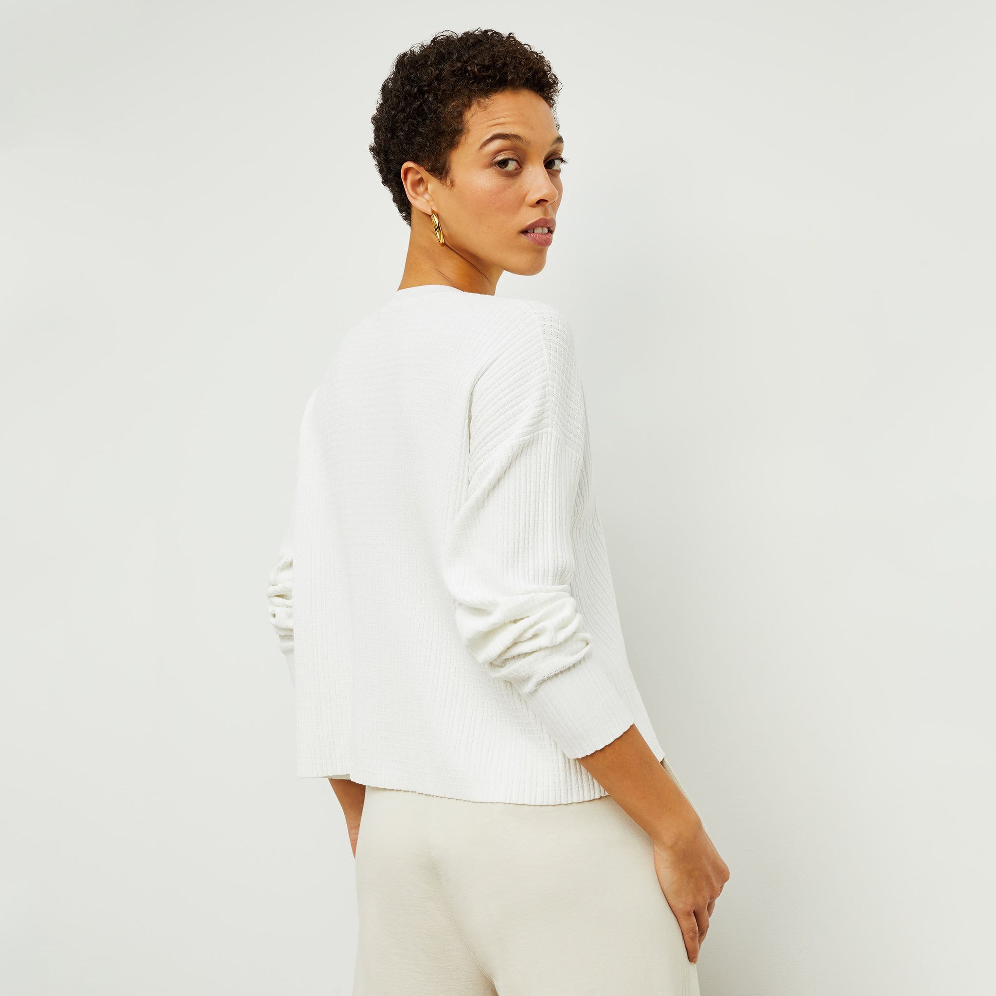 Back image of a woman standing wearing the tyler sweatshirt in ivory