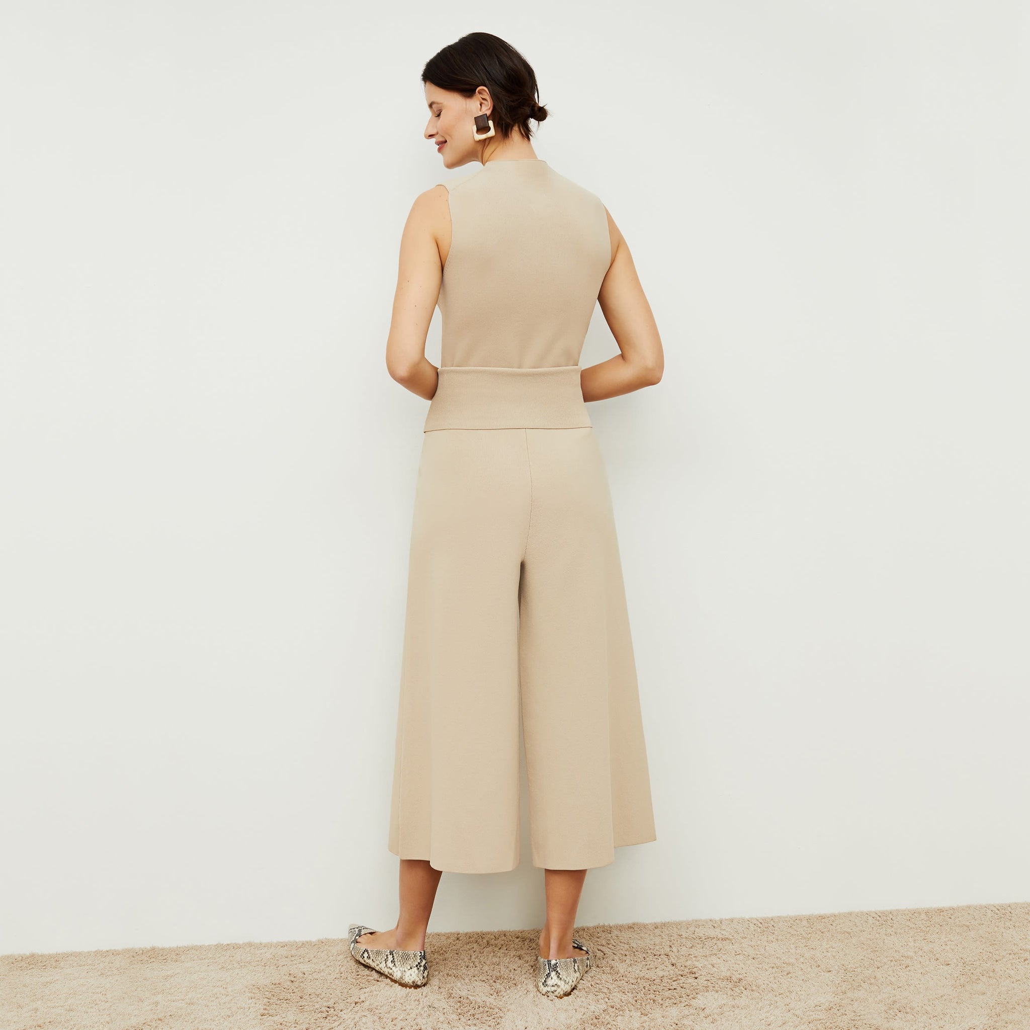 Back image of a woman standing wearing the rogala culotte in latte