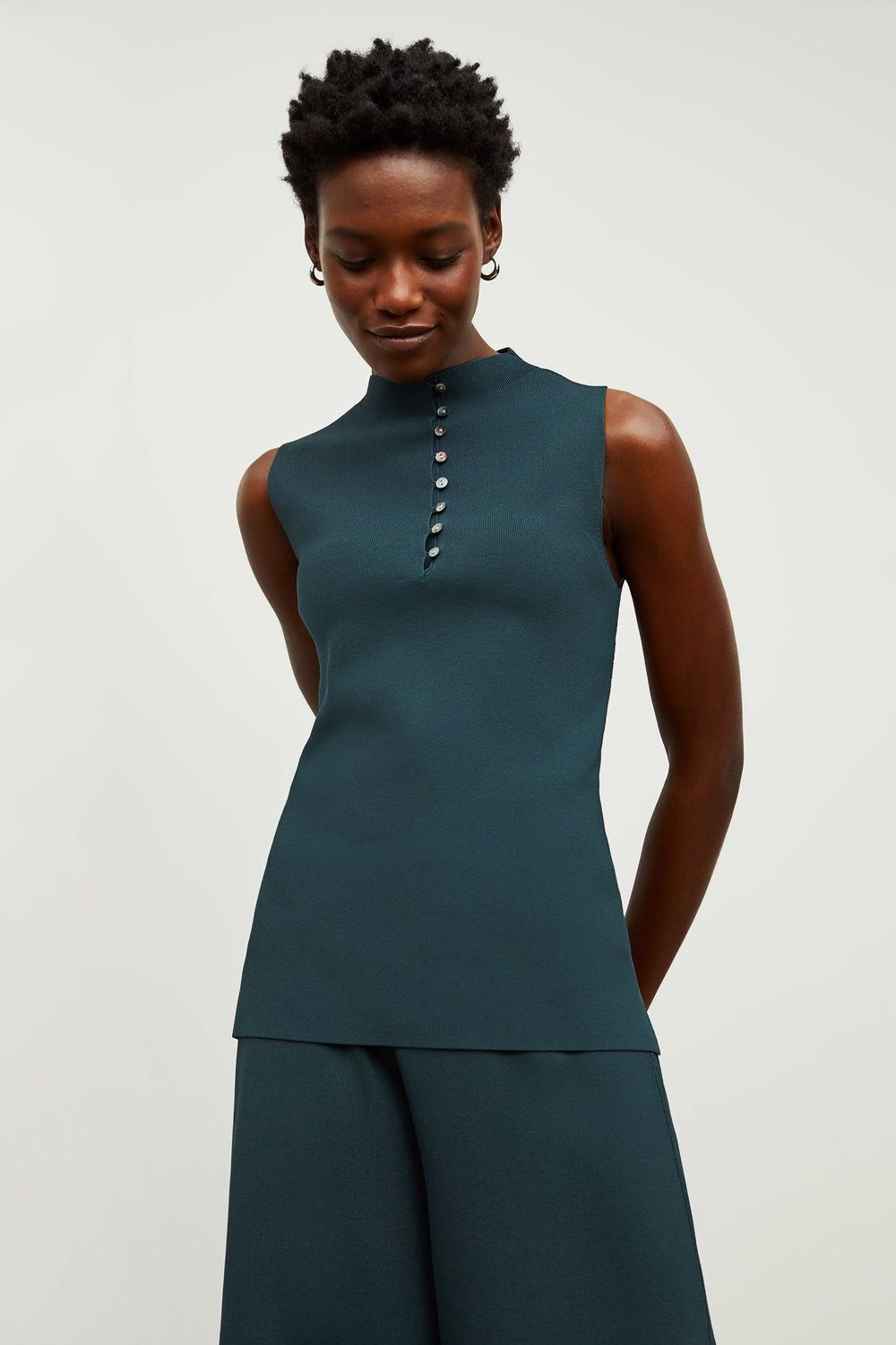 Front image of a woman standing wearing the malki top in deep sea