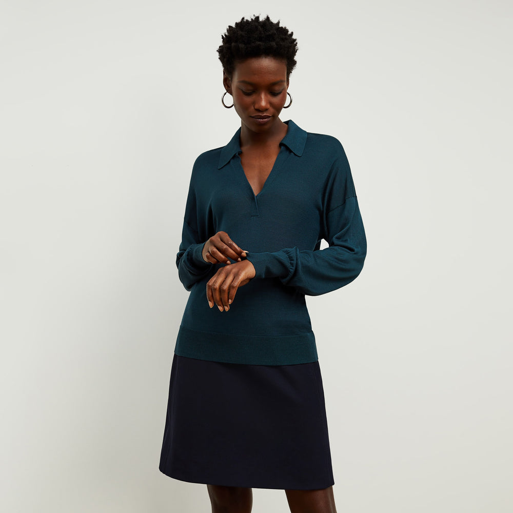 Front image of a woman standing wearing the leo top in deep sea