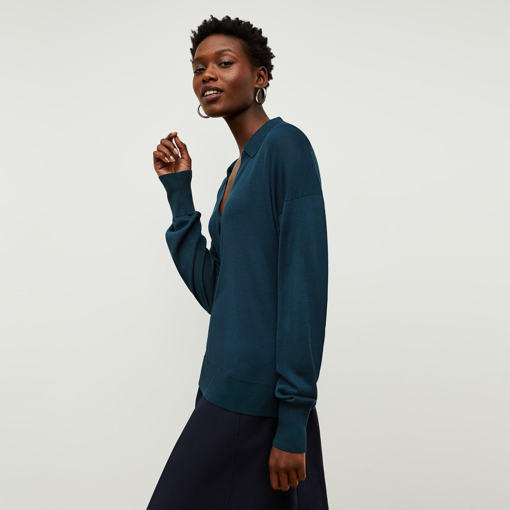 Side image of a woman standing wearing the leo top in deep sea