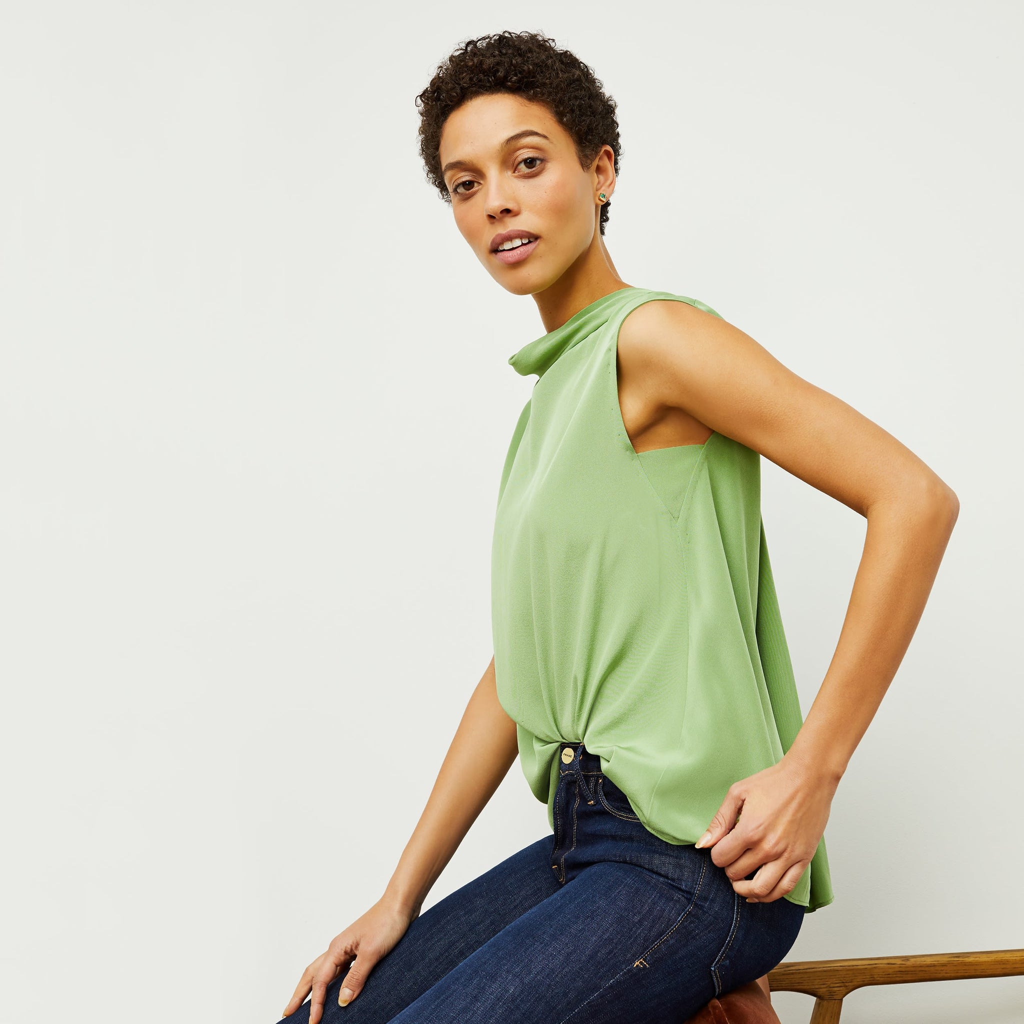 Side image of a woman standing wearing the Daisy Top—Washable Silk in Cactus