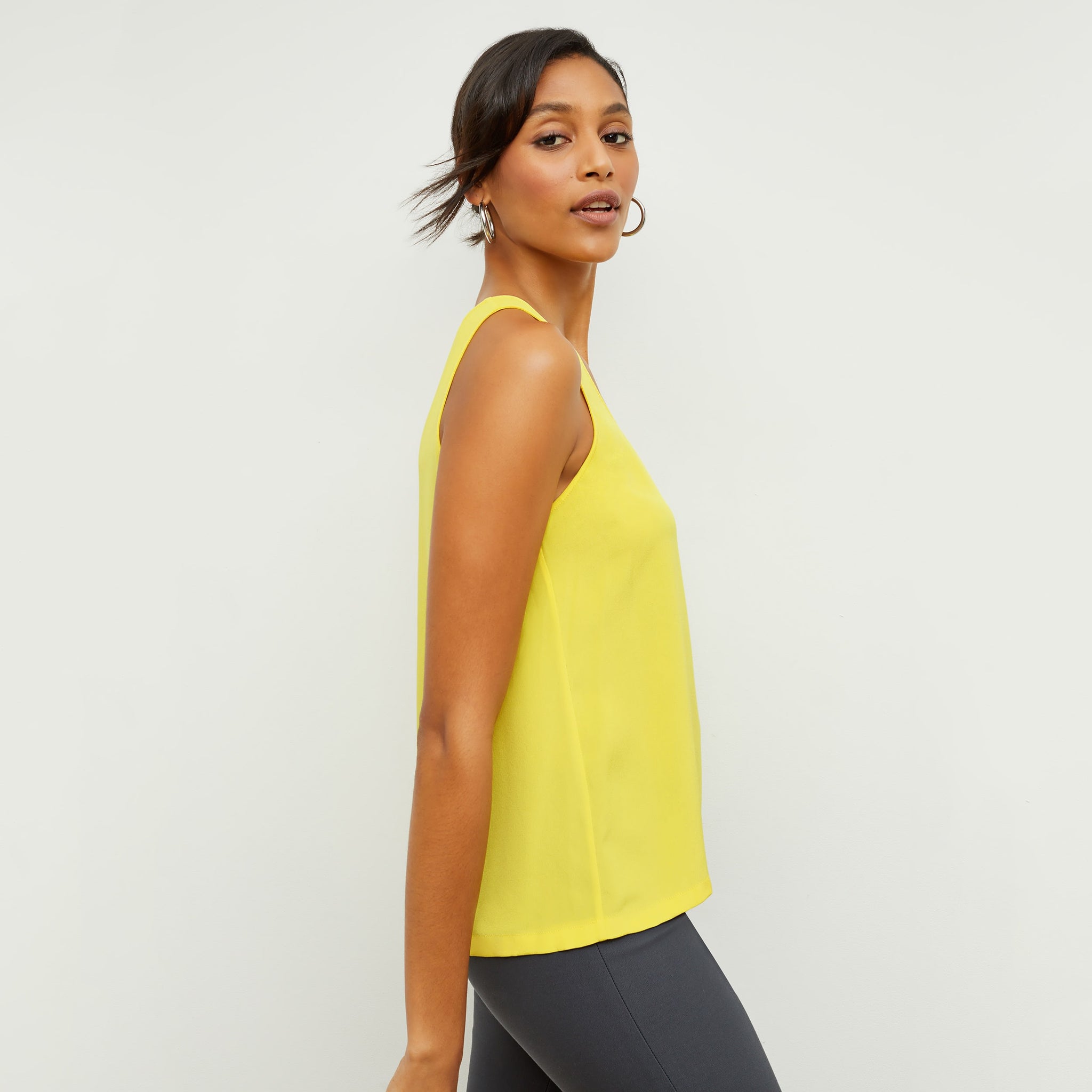 Side image of a woman standing wearing the Vicky Tank—Washable Silk in Sunshine