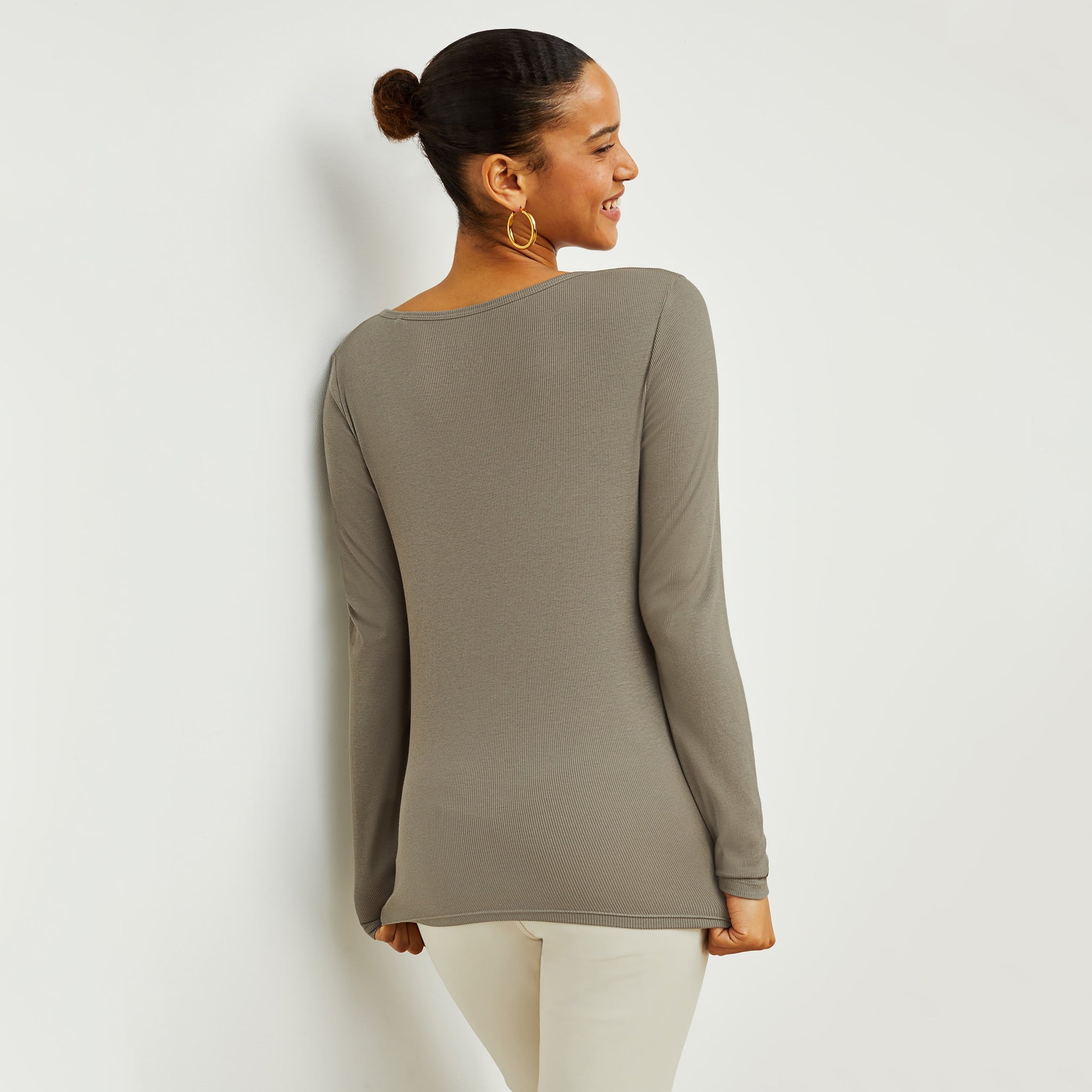 Back image of a woman standing wearing the Marcia T-Shirt—Fine Ribbed Cotton in Pebble