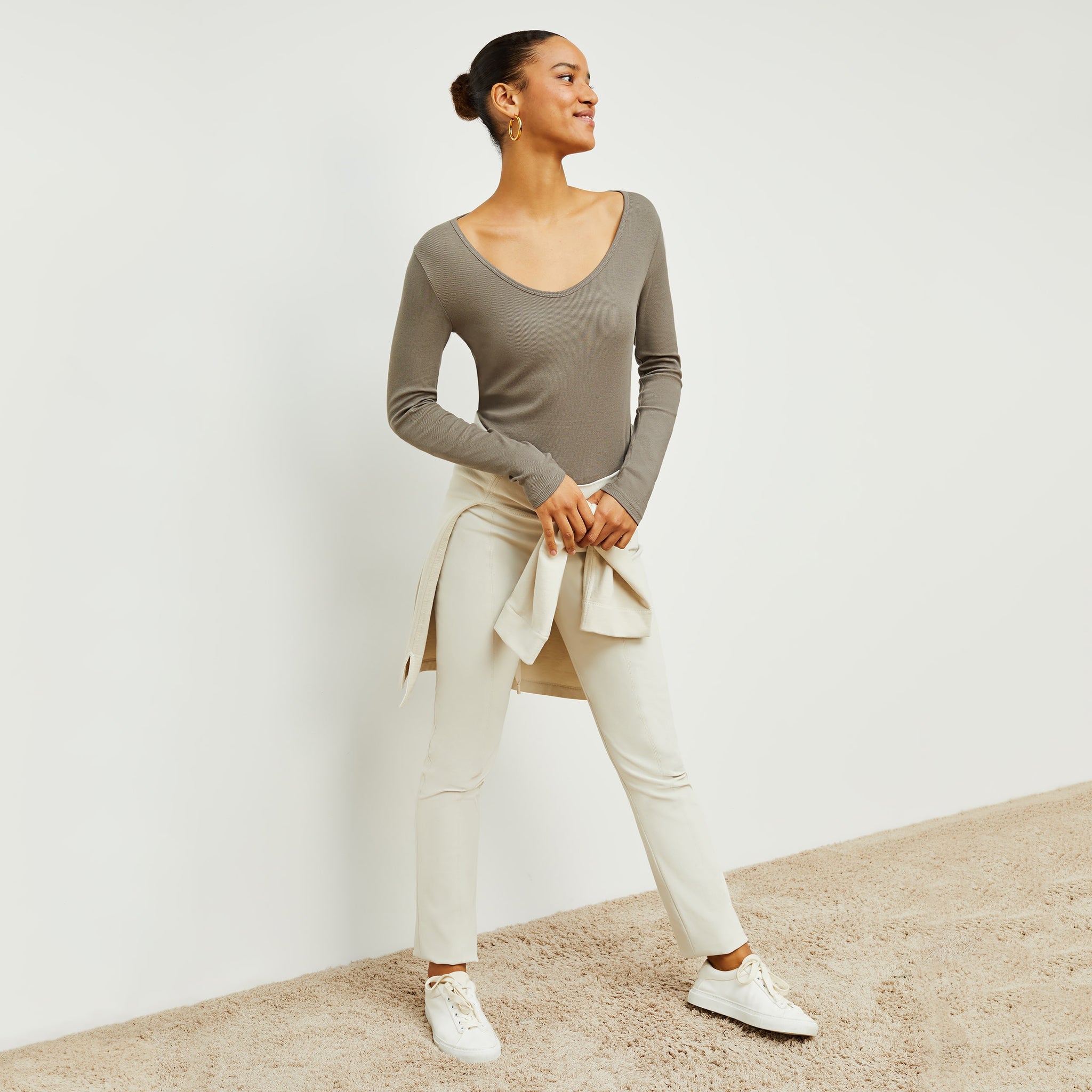 Front image of a woman standing wearing the Marcia T-Shirt—Fine Ribbed Cotton in Pebble