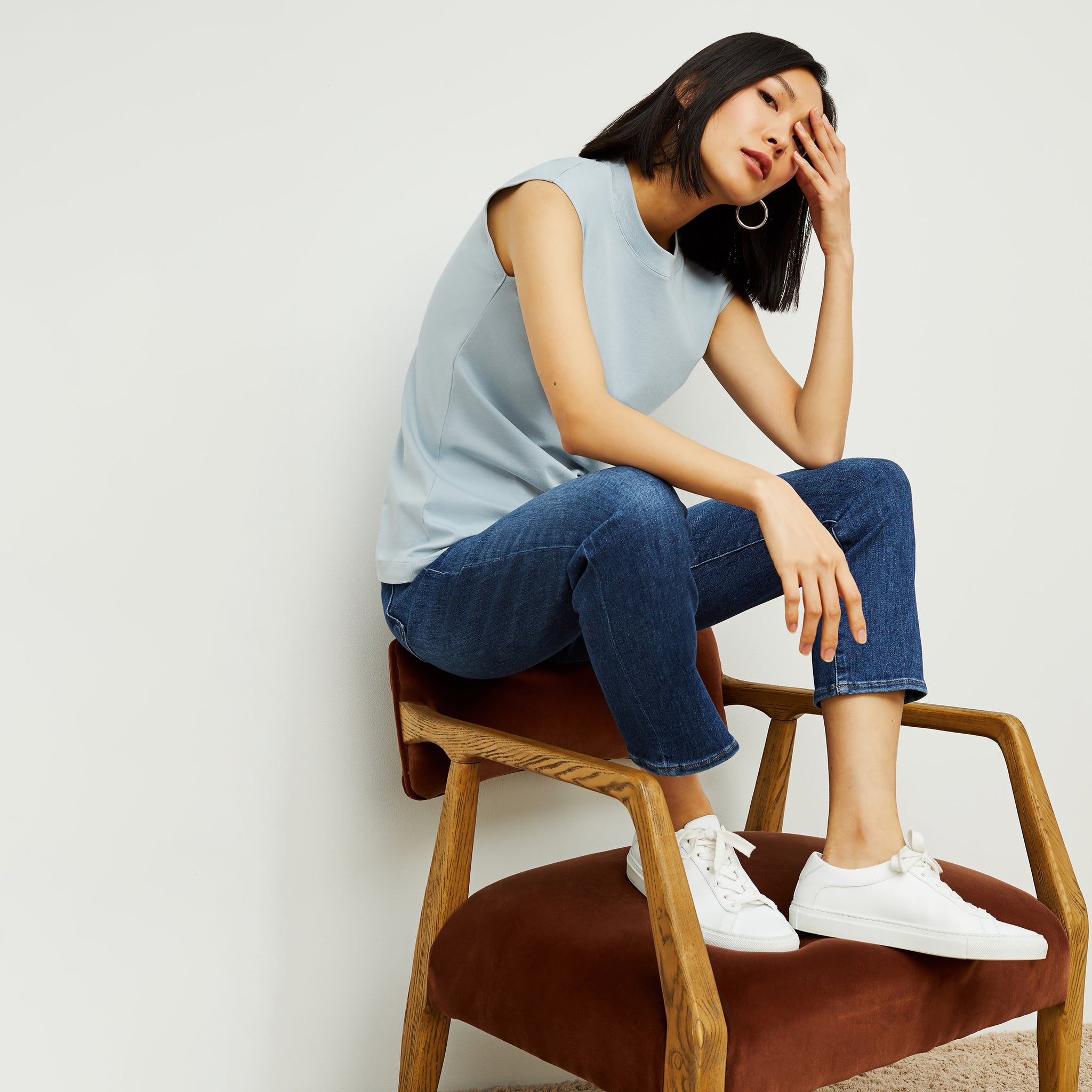 Side image of a woman standing wearing the Alina T-Shirt—Compact Cotton in Sky Blue