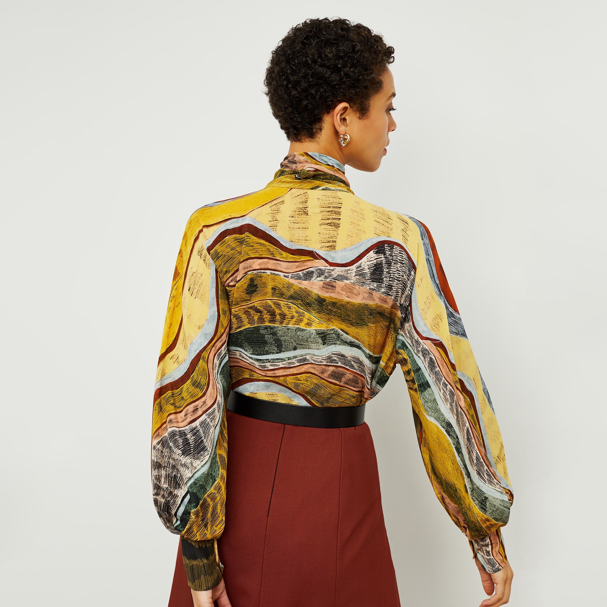 Back image of a woman standing wearing the Fiona Top—Silk Desert in Multicolor