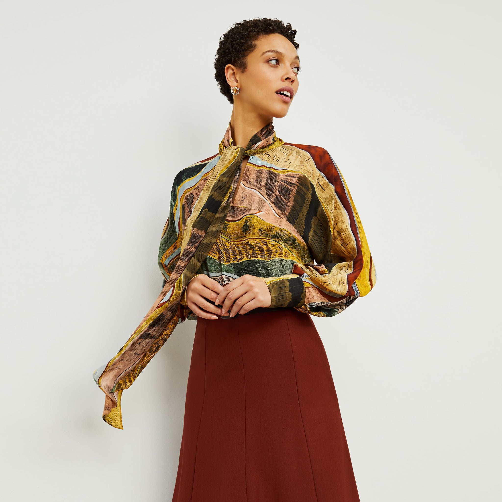 Front image of a woman standing wearing the Fiona Top—Silk Desert in Multicolor