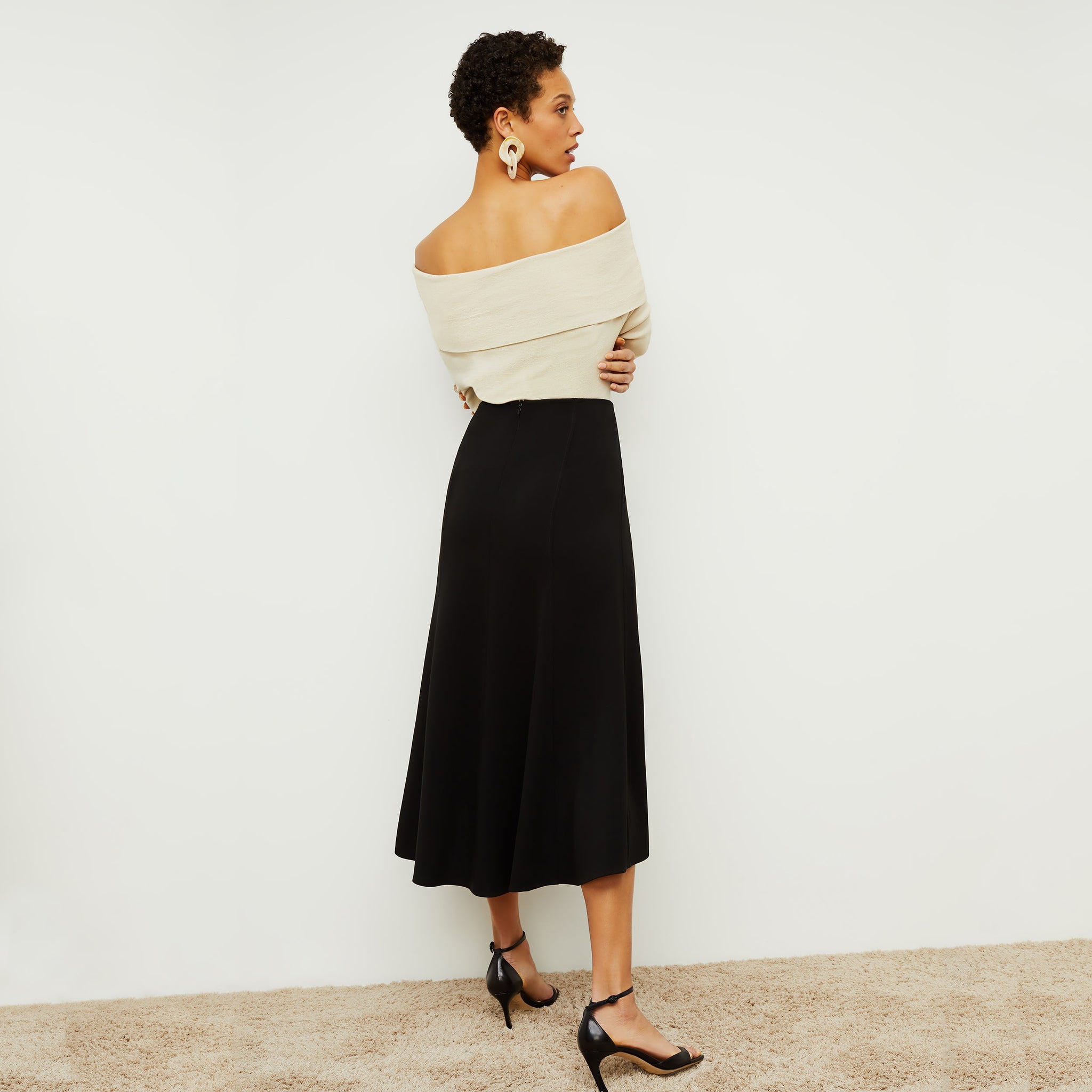 Back image of a woman standing wearing the Melrose Skirt in Black