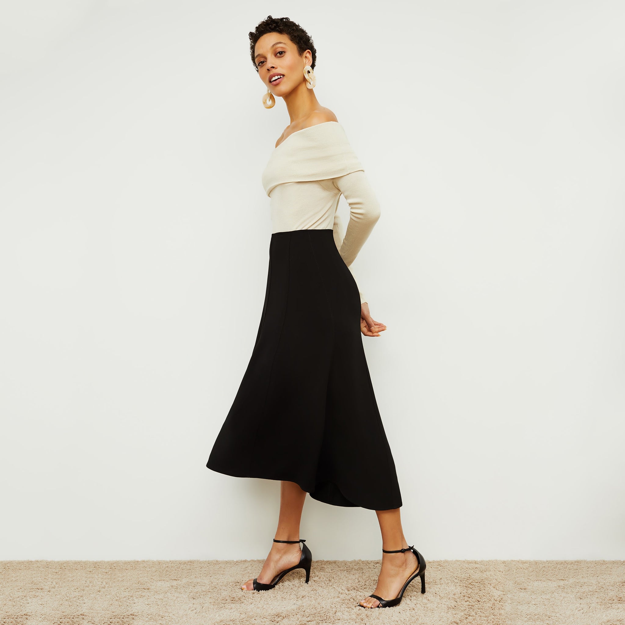 Side image of a woman standing wearing the Melrose Skirt in Black