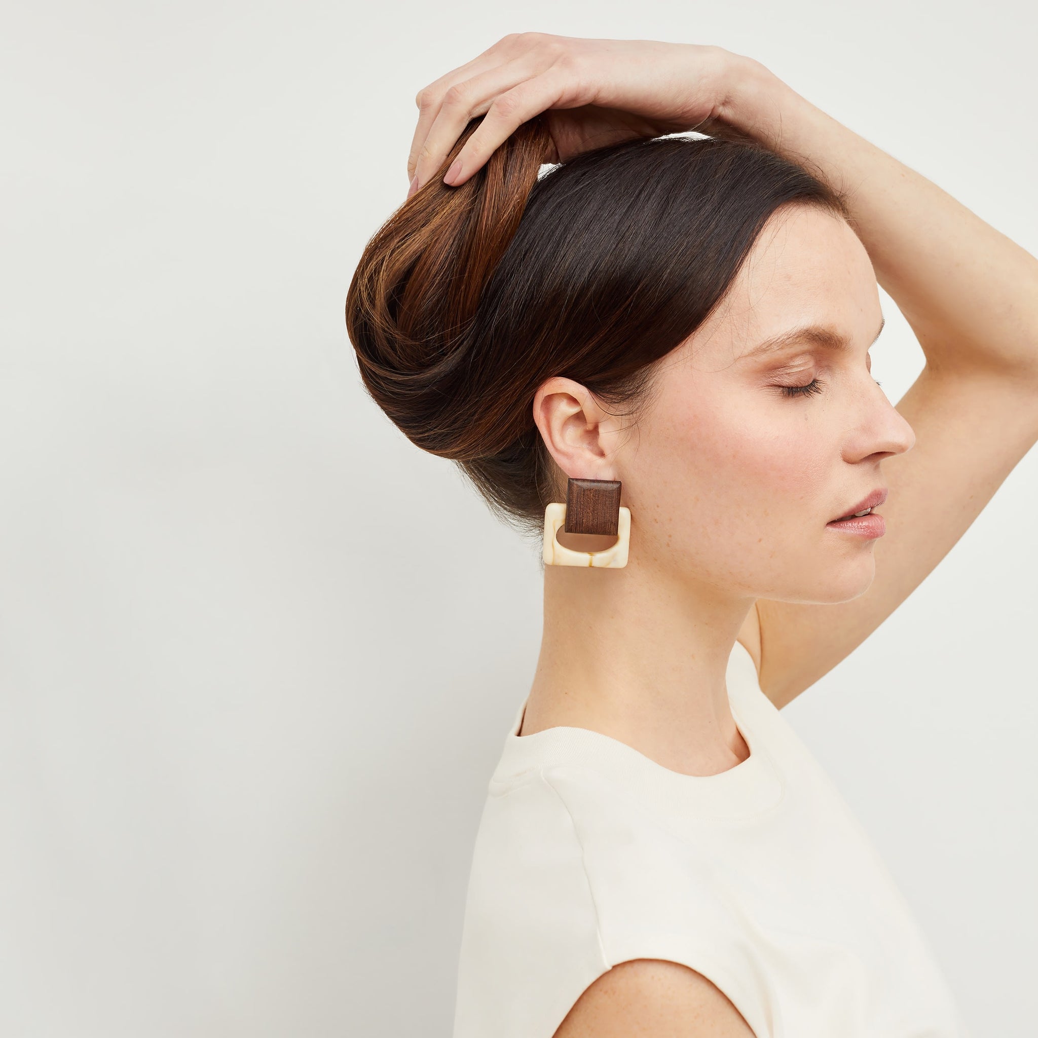 Front image of a woman standing wearing the Mardy Earrings in Brown / Ivory
