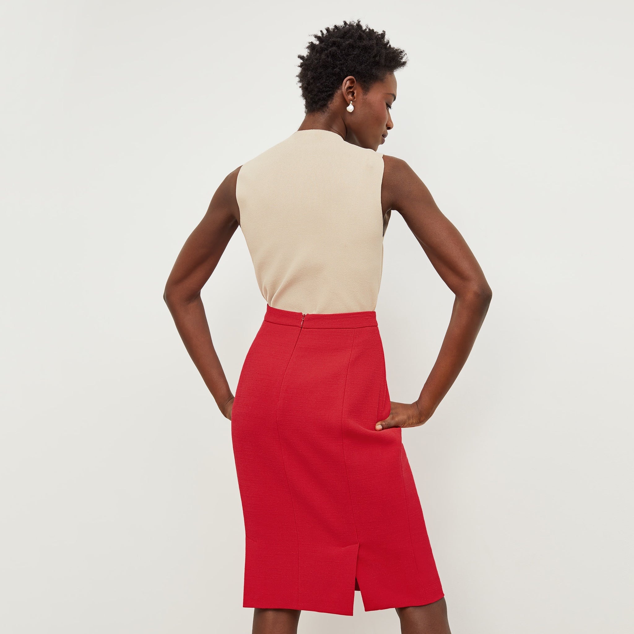 Back image of a woman standing wearing the Cobble Hill Skirt—Nep Suiting in Poppy