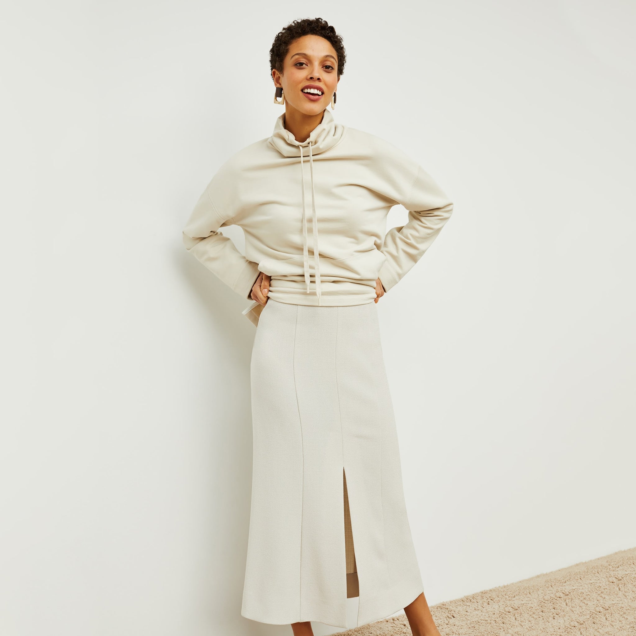 Front image of a woman standing wearing the eva skirt in textured suiting in magnolia 