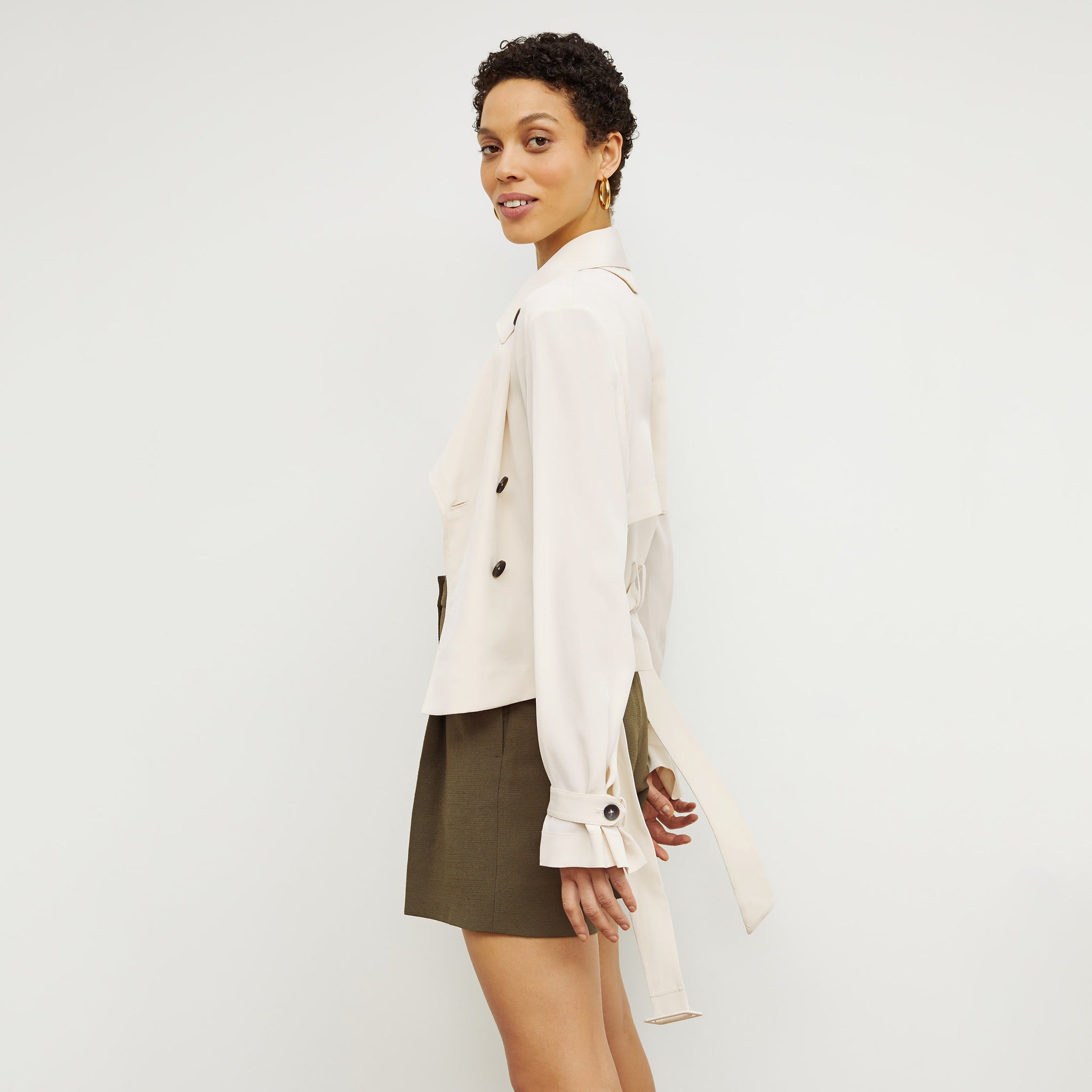 Side image of a woman standing wearing the Scotte Jacket—SustainSilk in Pearl