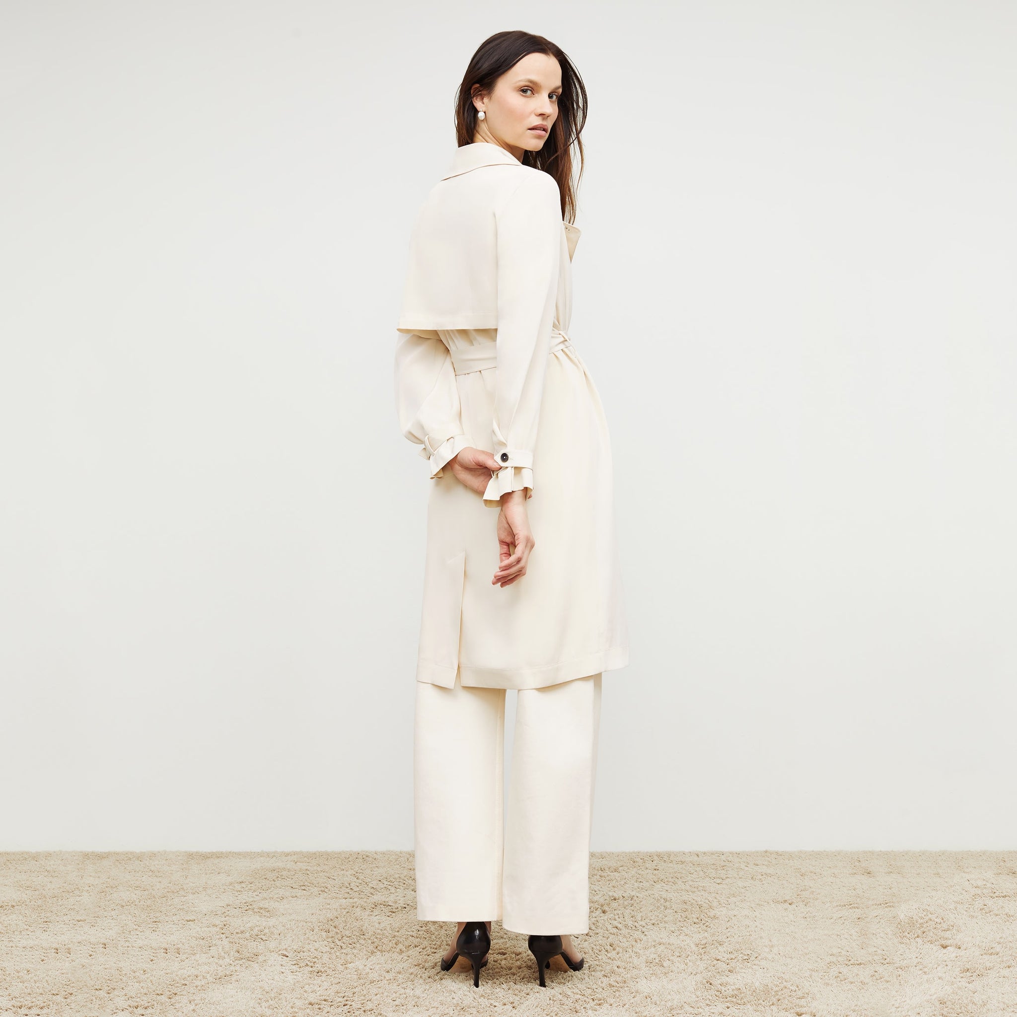 Back image of a woman standing wearing the Jensen Trench—SustainSilk in Pearl