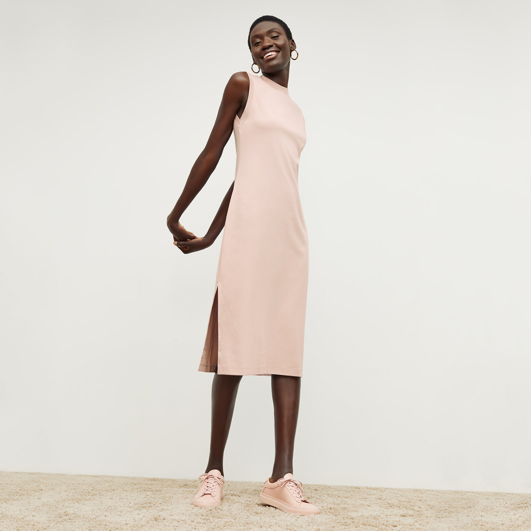 Front image of a woman standing wearing the Lou Dress—Compact Cotton in Dusty Pink