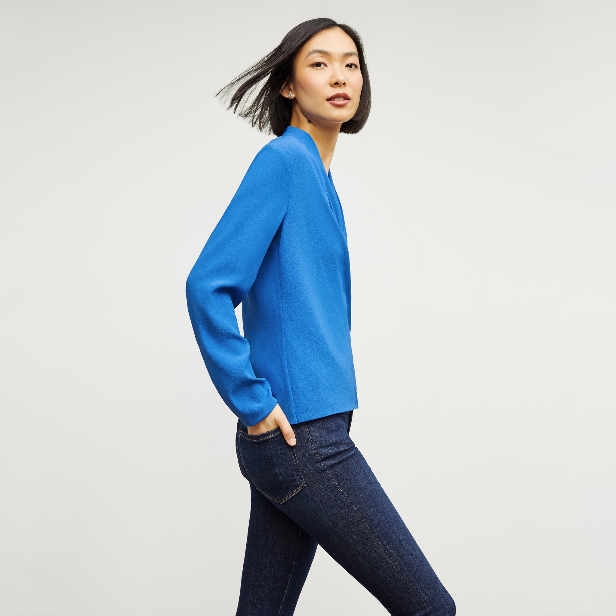 Side image of a woman standing wearing the antoinette top in soft wave in olympic blue