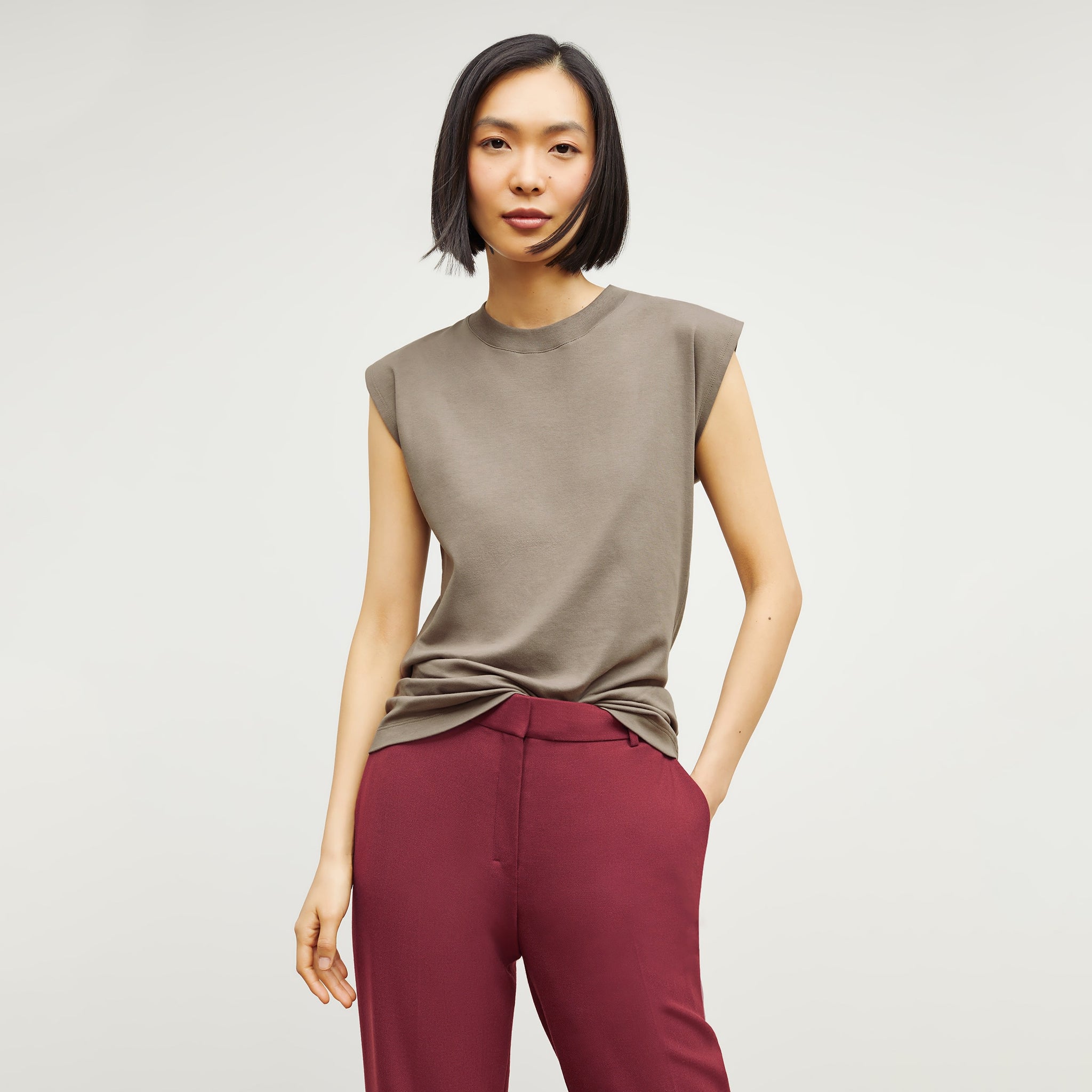 Front image of a woman standing wearing the Alina T-Shirt—Compact Cotton in Pebble