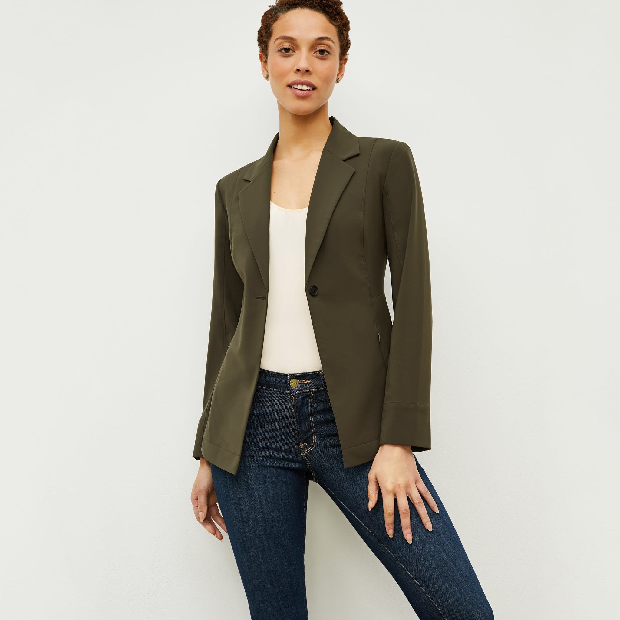 Front image of a woman standing wearing the Moreland jacket in olive