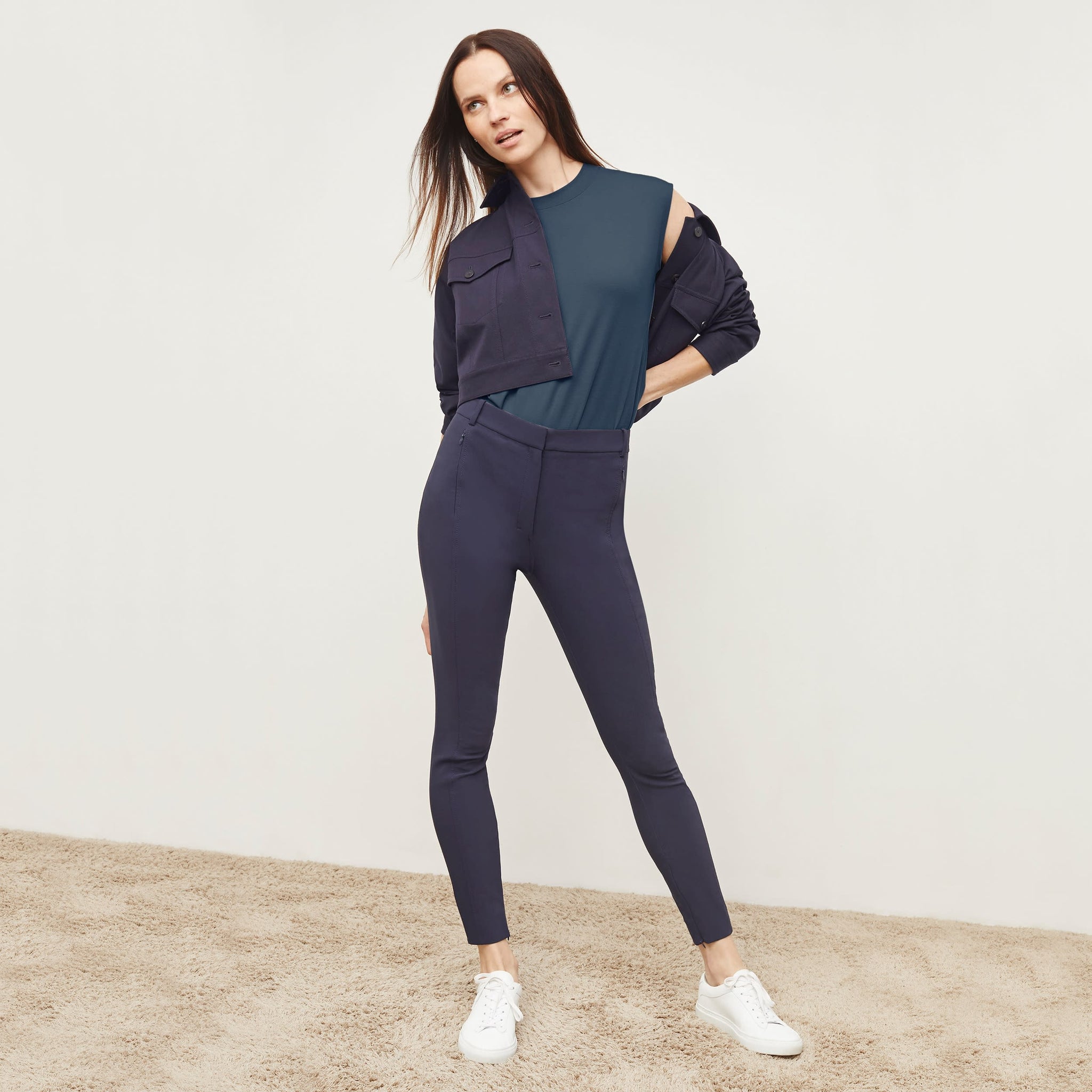 Front image of a woman standing wearing the curie pant in dark navy