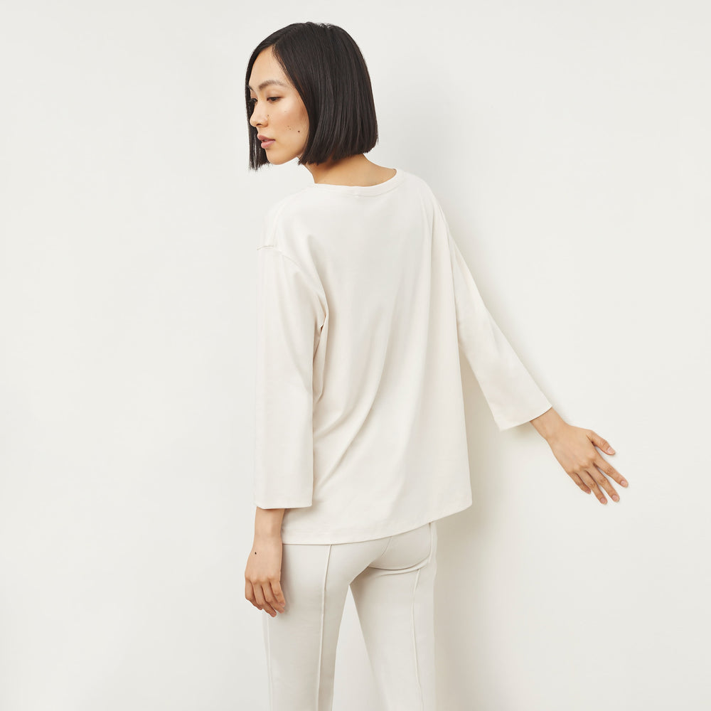 Back image of a woman standing wearing the Owen T-Shirt—Pima Cotton in Ivory