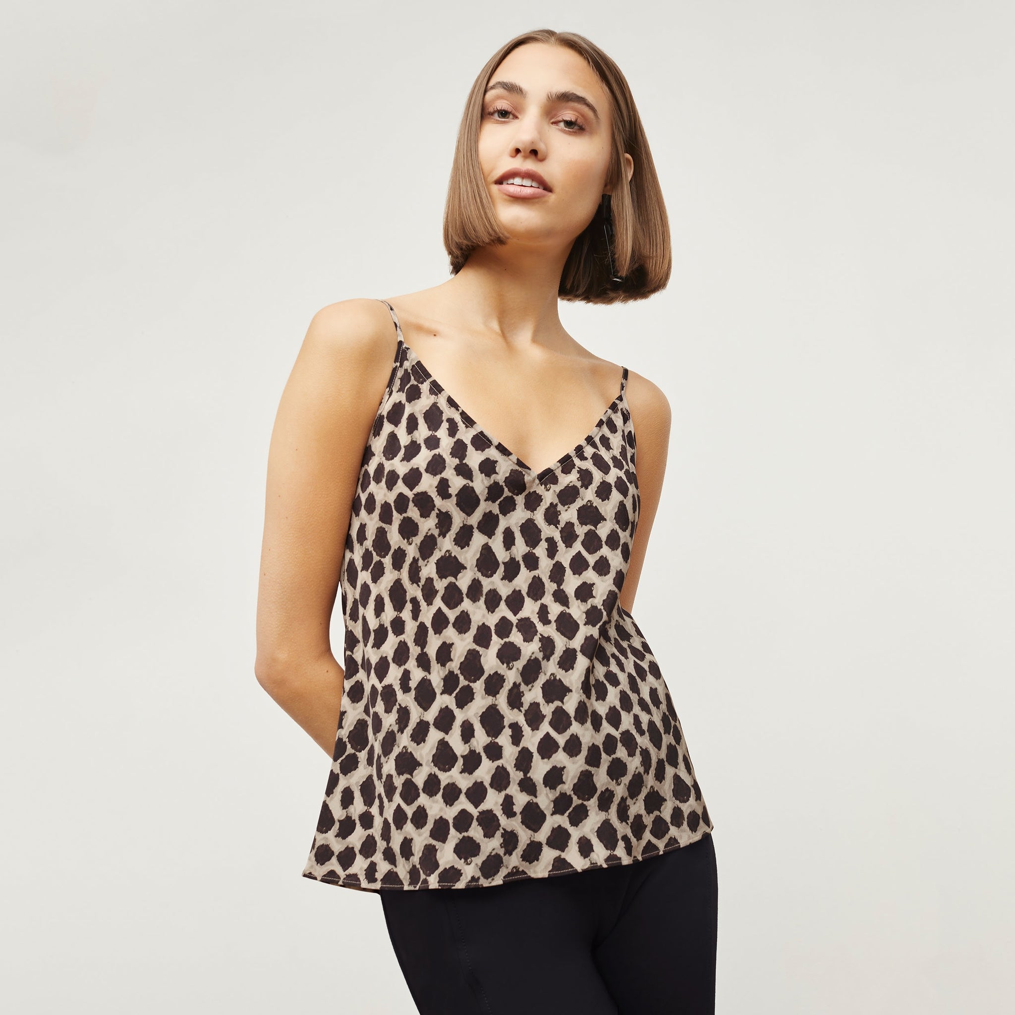 Front image of a woman standing wearing the Lisey Cami—Sahara Print Washable Silk in Tan/Black 
