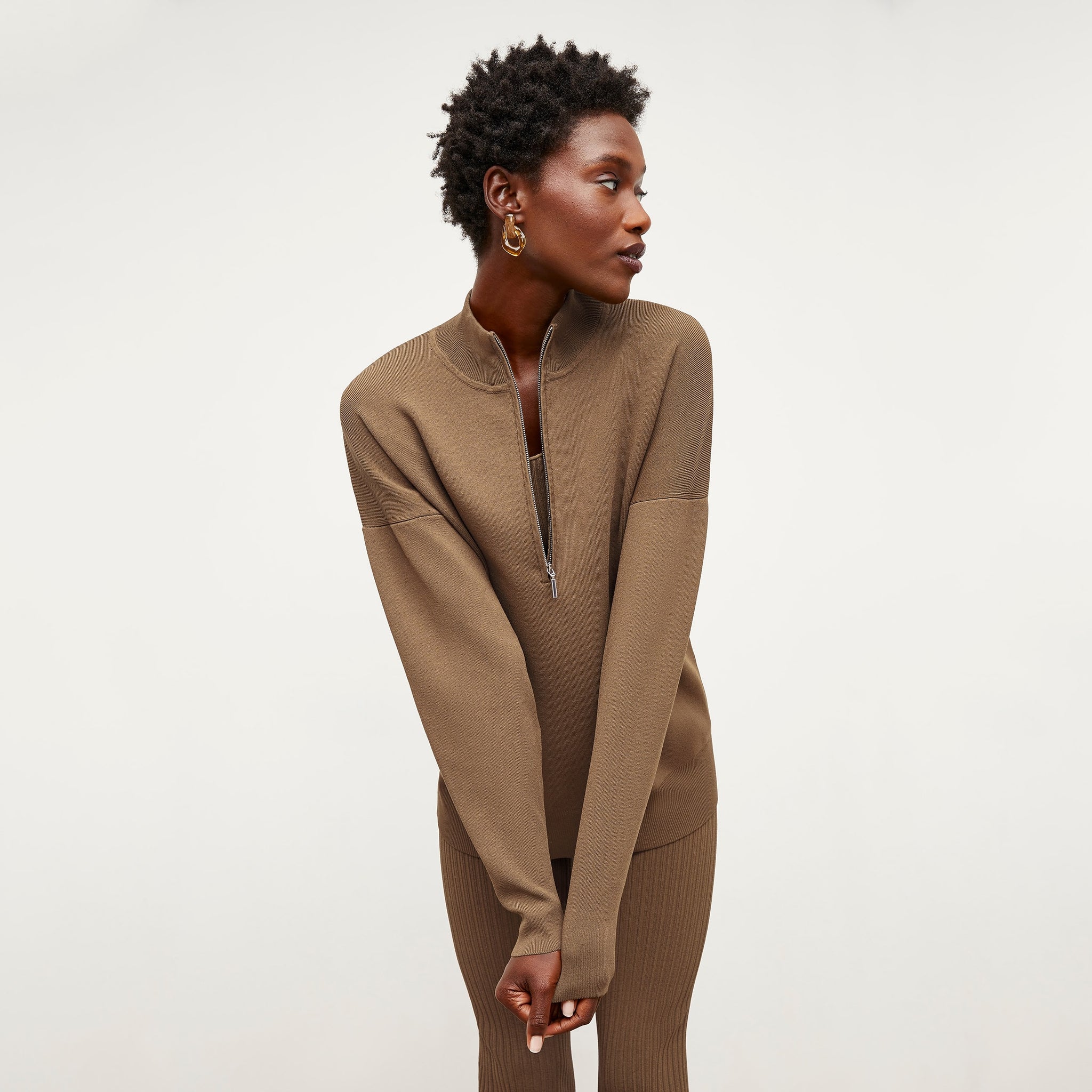 Front image of a woman standing wearing the Athens Half Zip—Jardigan Knit in Light Bronze