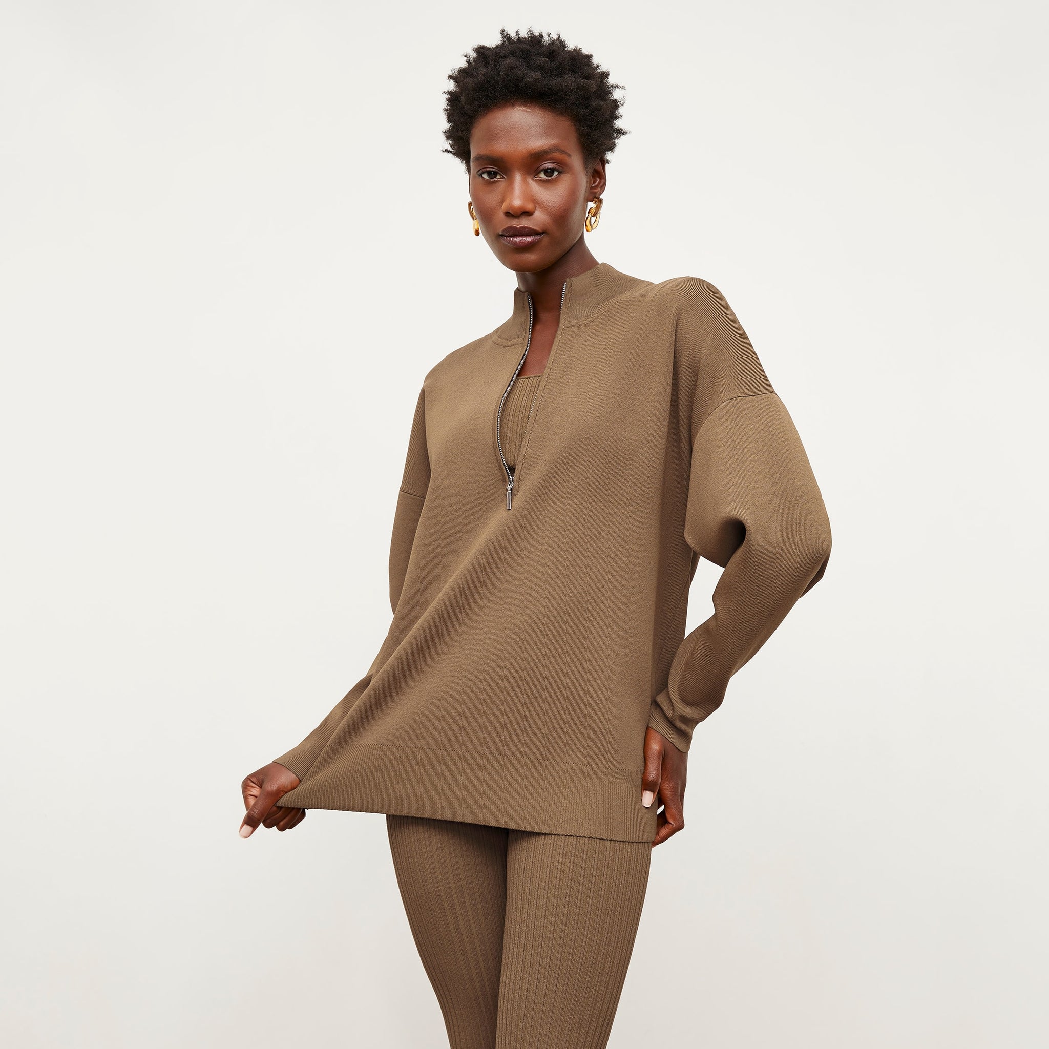Front image of a woman standing wearing the Athens Half Zip—Jardigan Knit in Light Bronze 