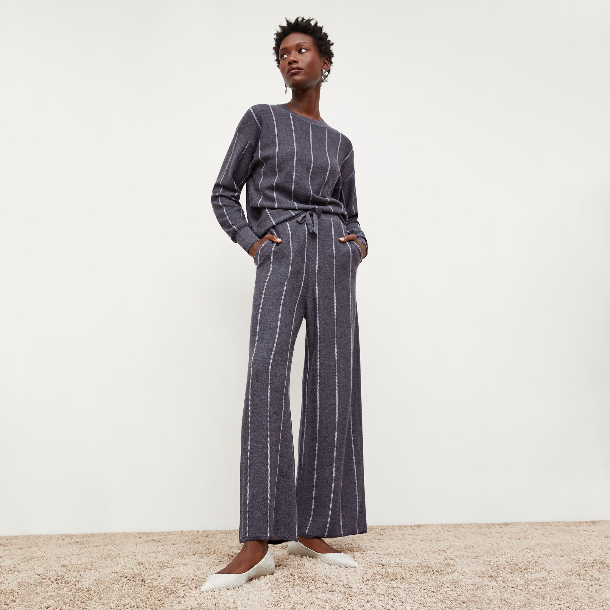 Front image of a woman standing wearing the tressa pant in braided stripe in charcoal and ivory 