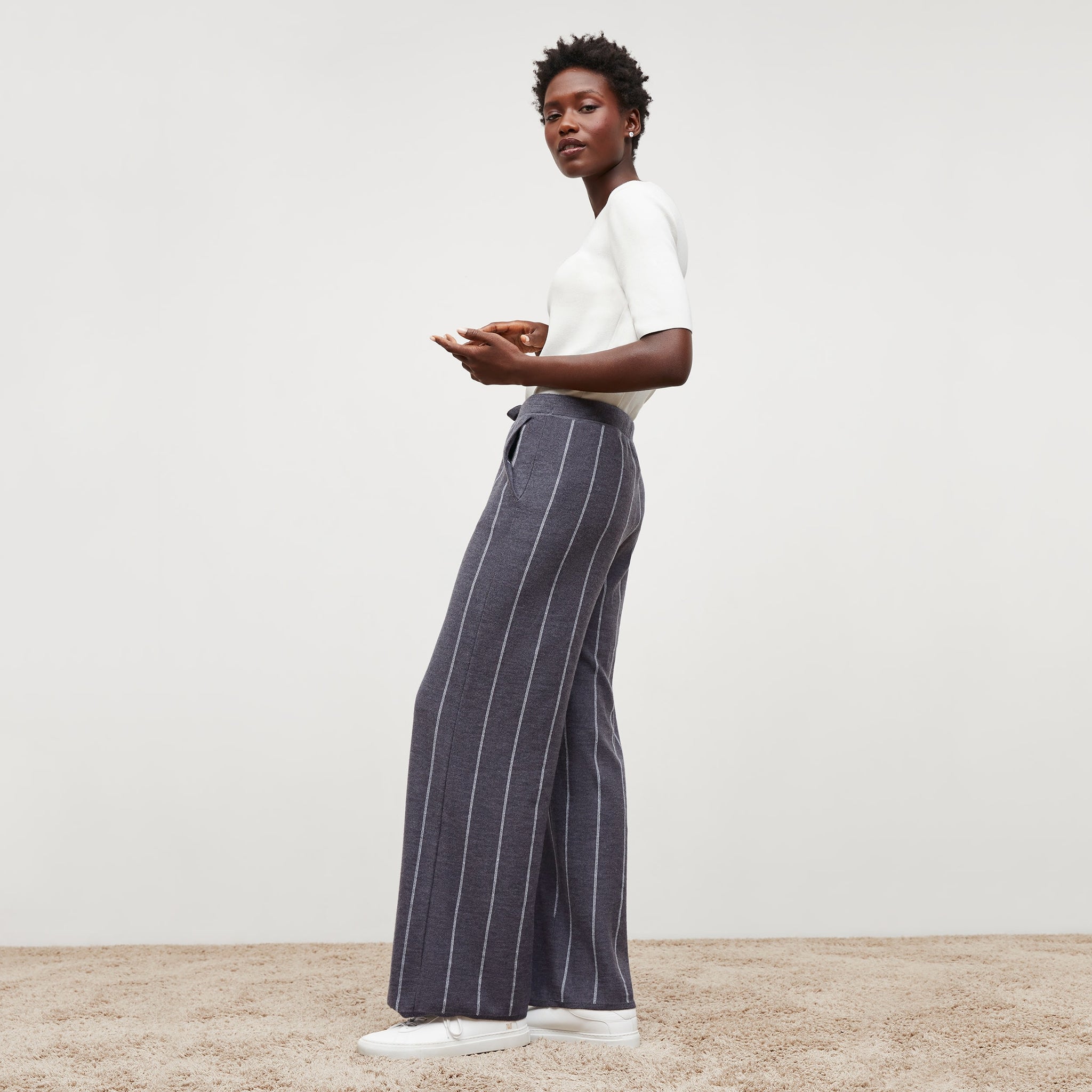 Side image of a woman standing wearing the tressa pant in braided stripe in charcoal and ivory