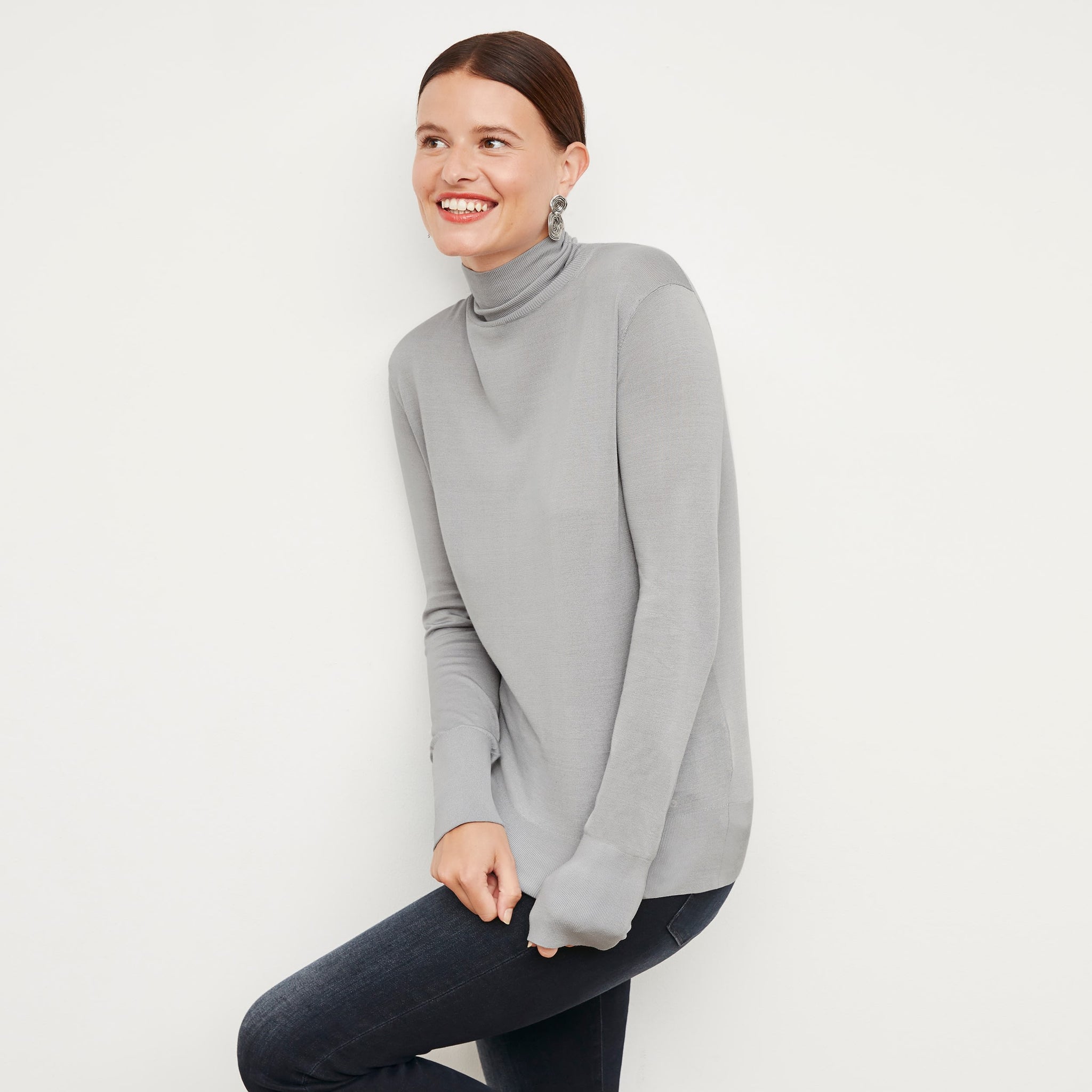 Front image of a woman standing wearing the elizabeth top in silk jersey in pale gray