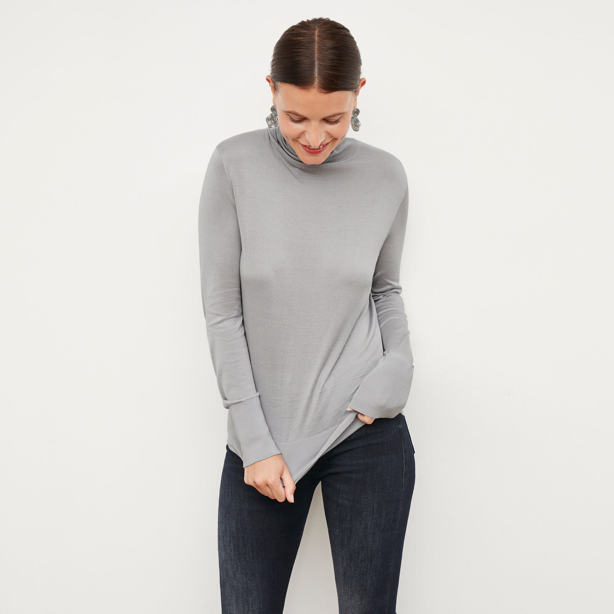 Front image of a woman standing wearing the elizabeth top in silk jersey in pale gray 