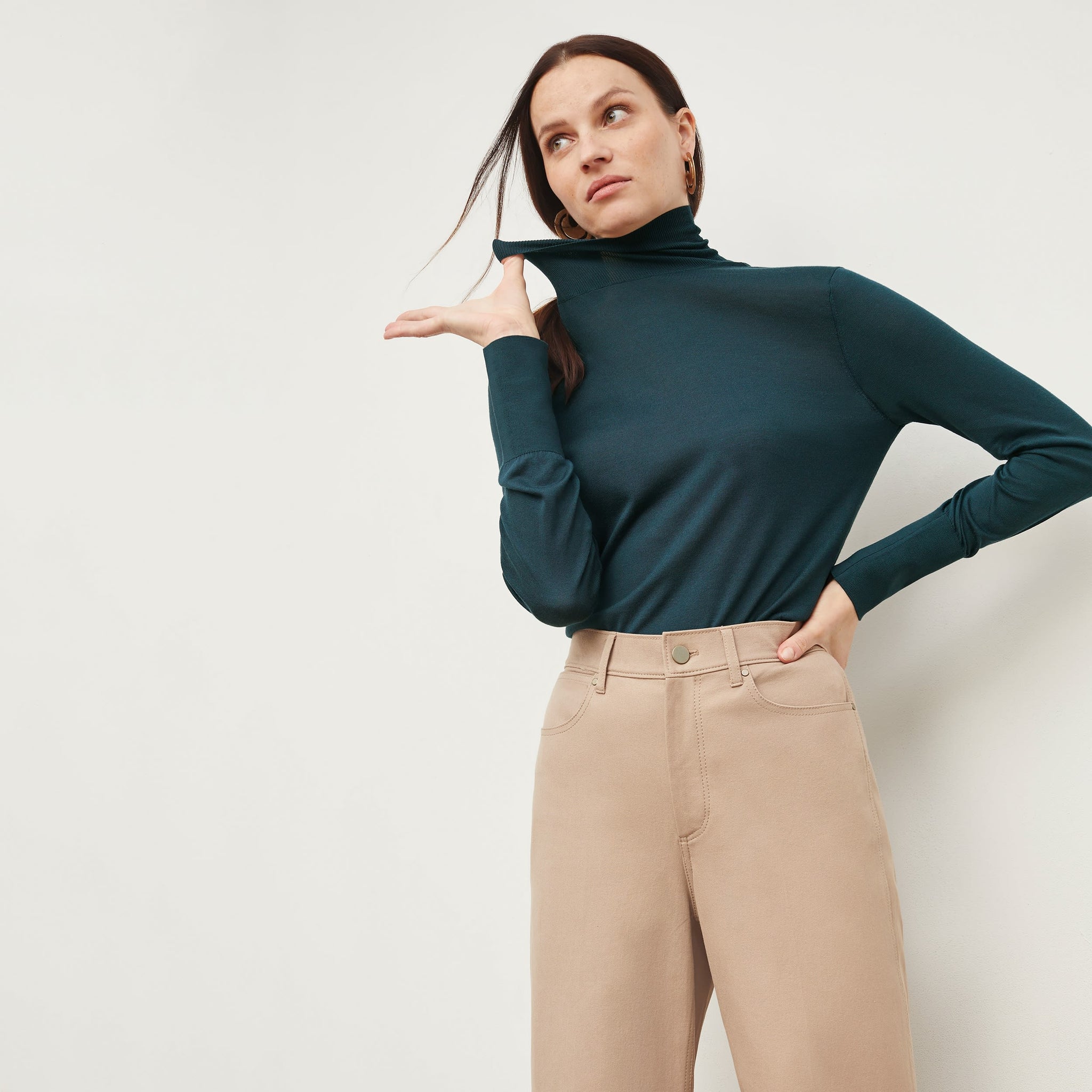 Front image of a woman standing wearing the Milo jean in Beige