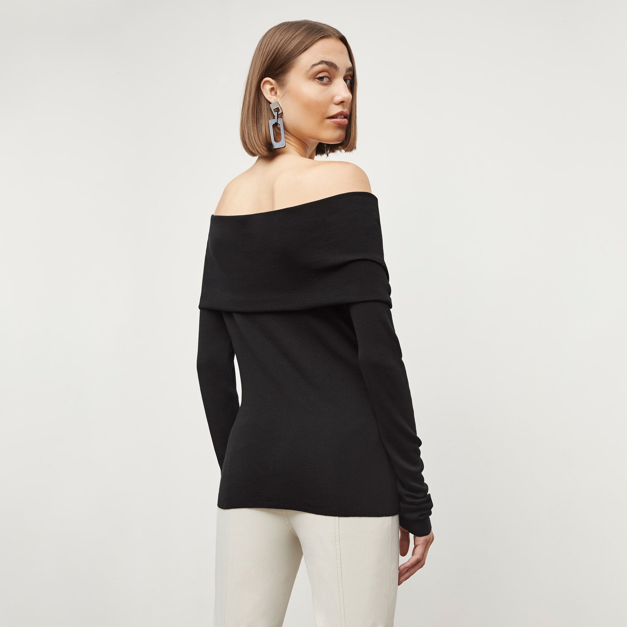 Back image of a woman standing wearing the dae top in silk jersey in black