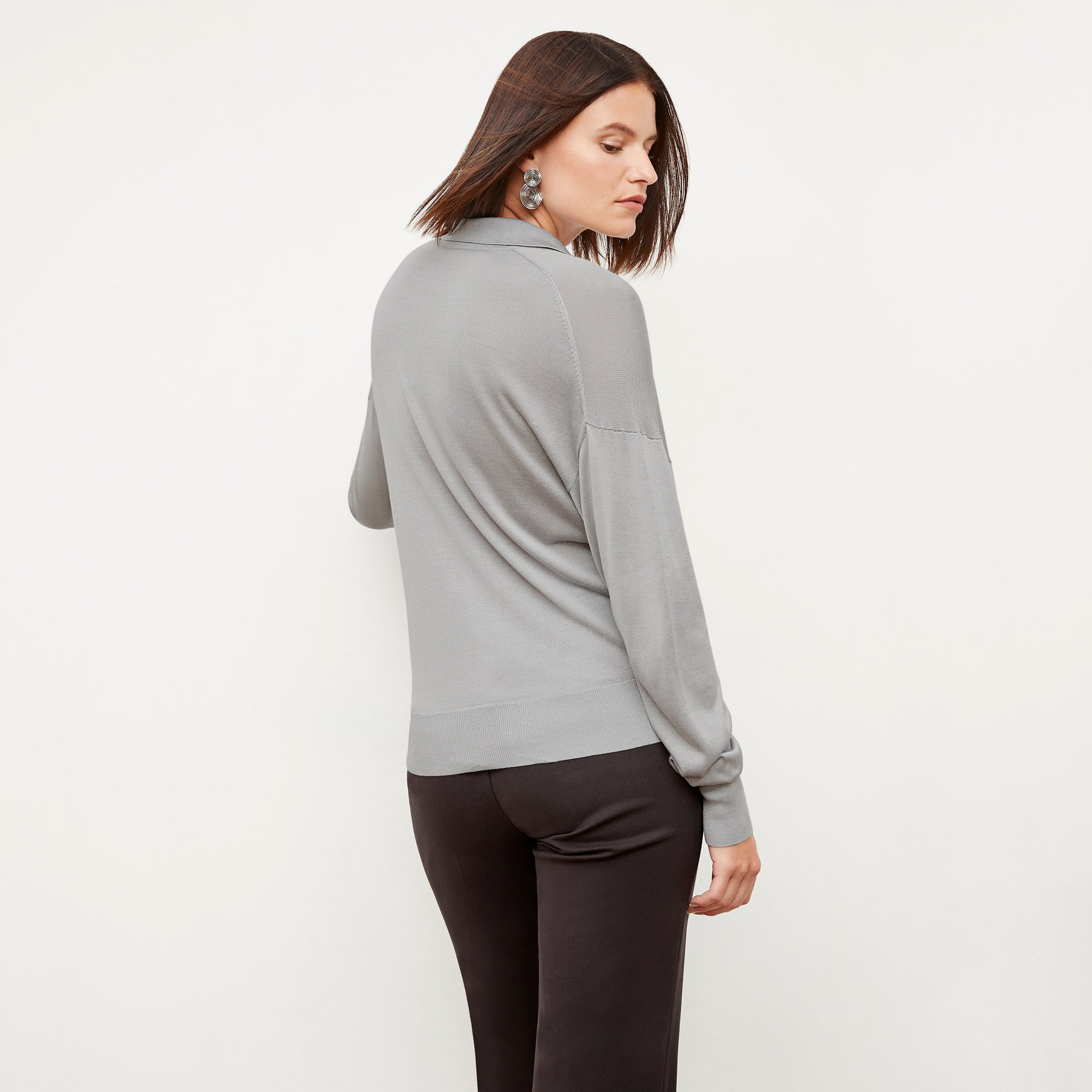 Back image of a woman standing wearing the leo top in silk jersey in pale gray