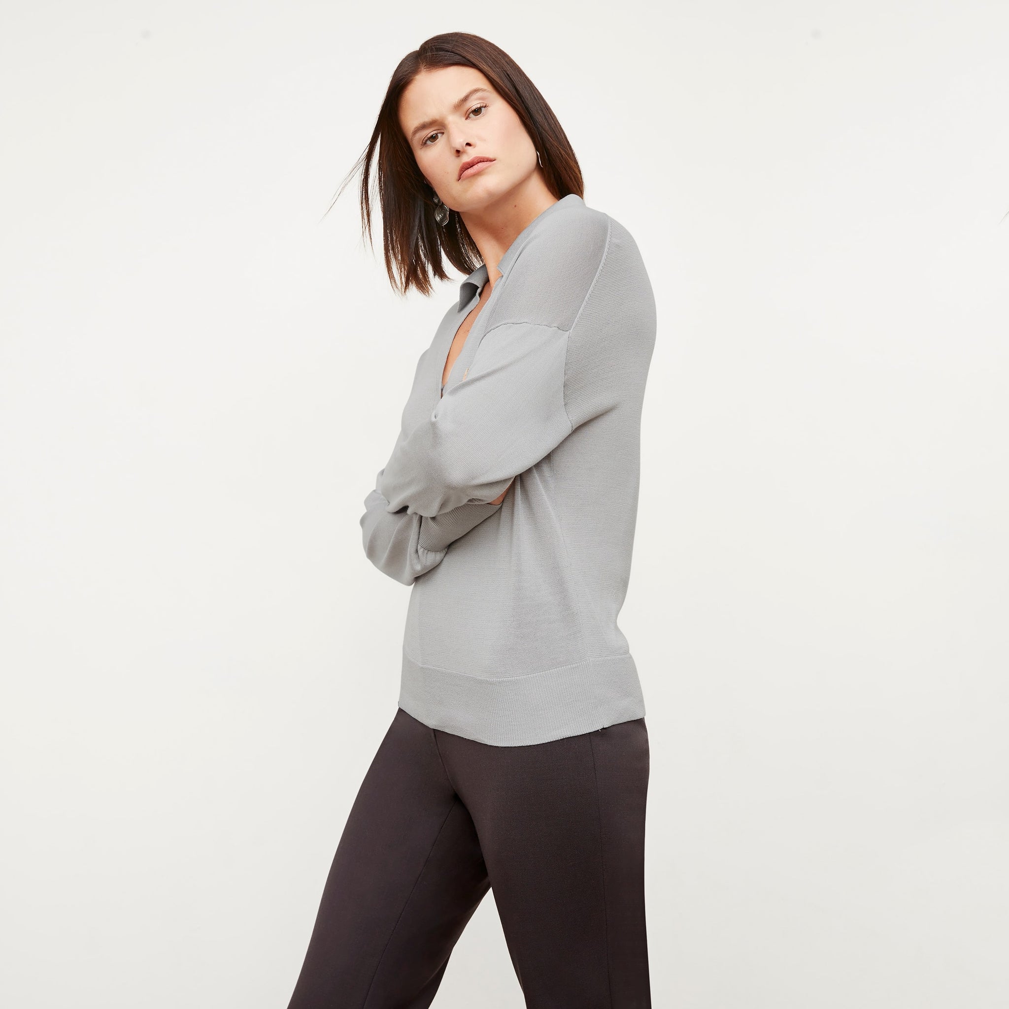 Side image of a woman standing wearing the leo top in silk jersey in pale gray