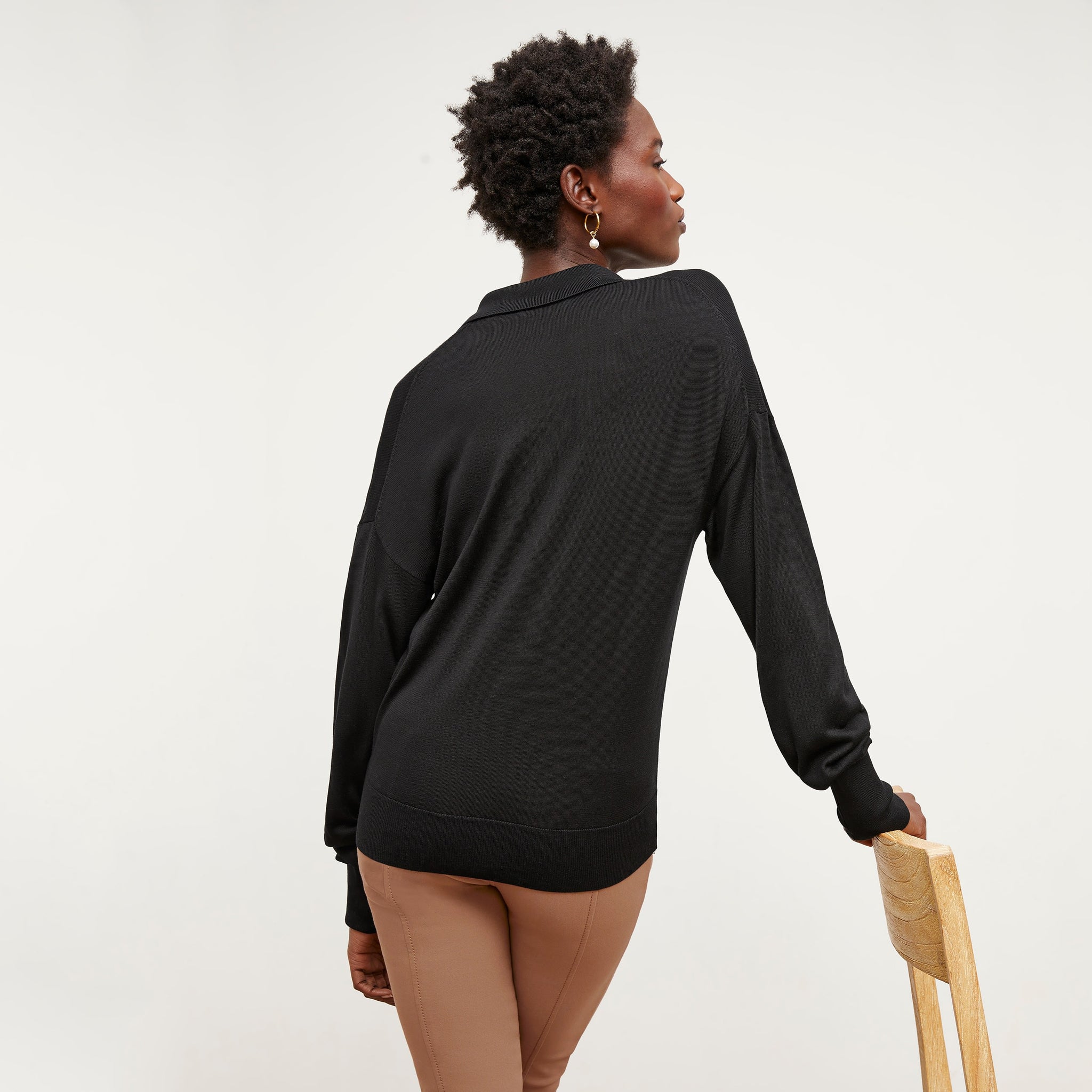 Back image of a woman standing wearing the leo top in silk jersey in black